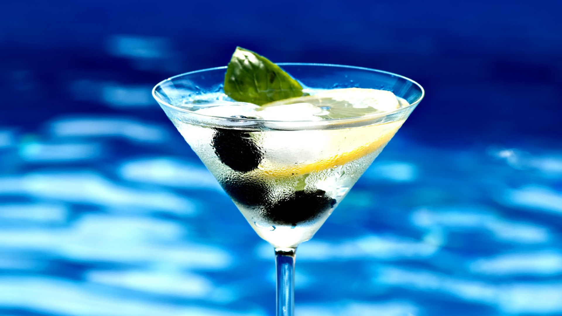 Мартини в бокале с лимоном и оливками 