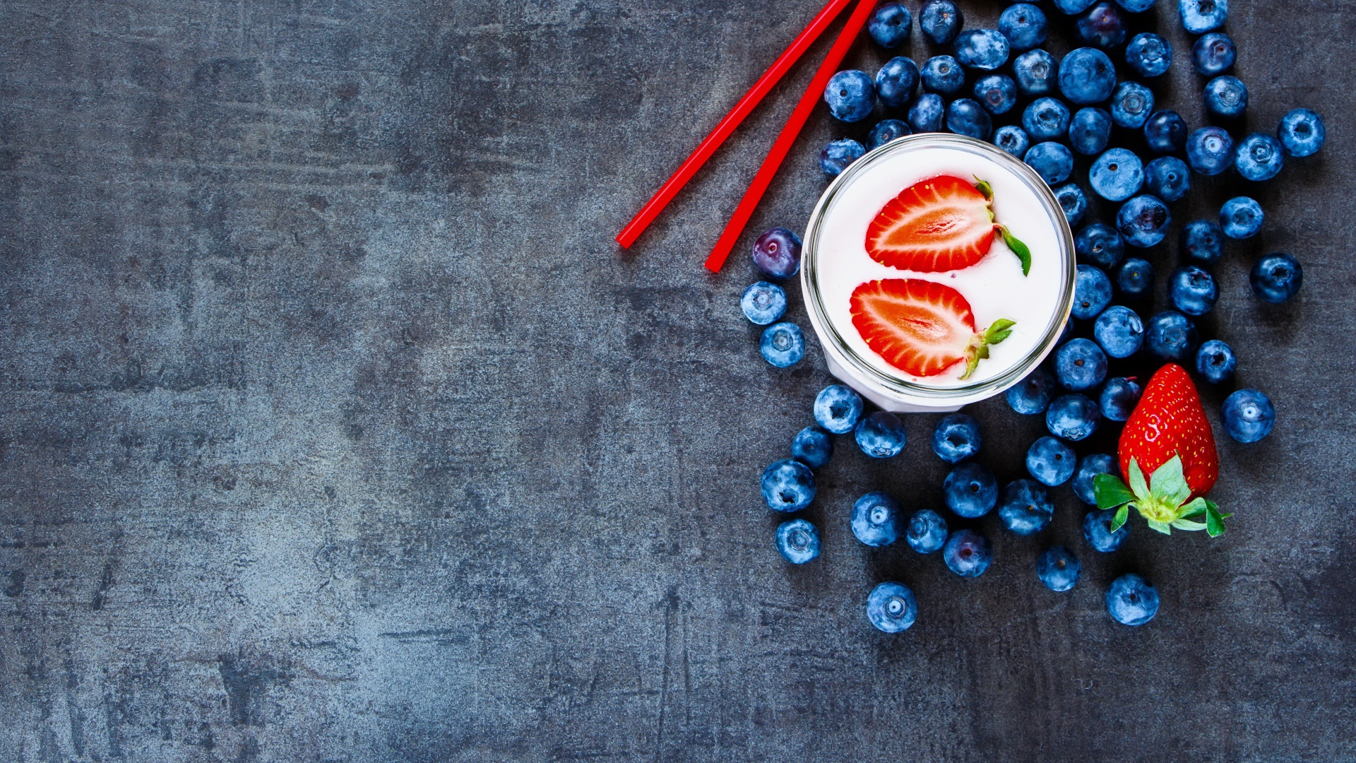 Молочный коктейль с клубникой и черникой на столе 