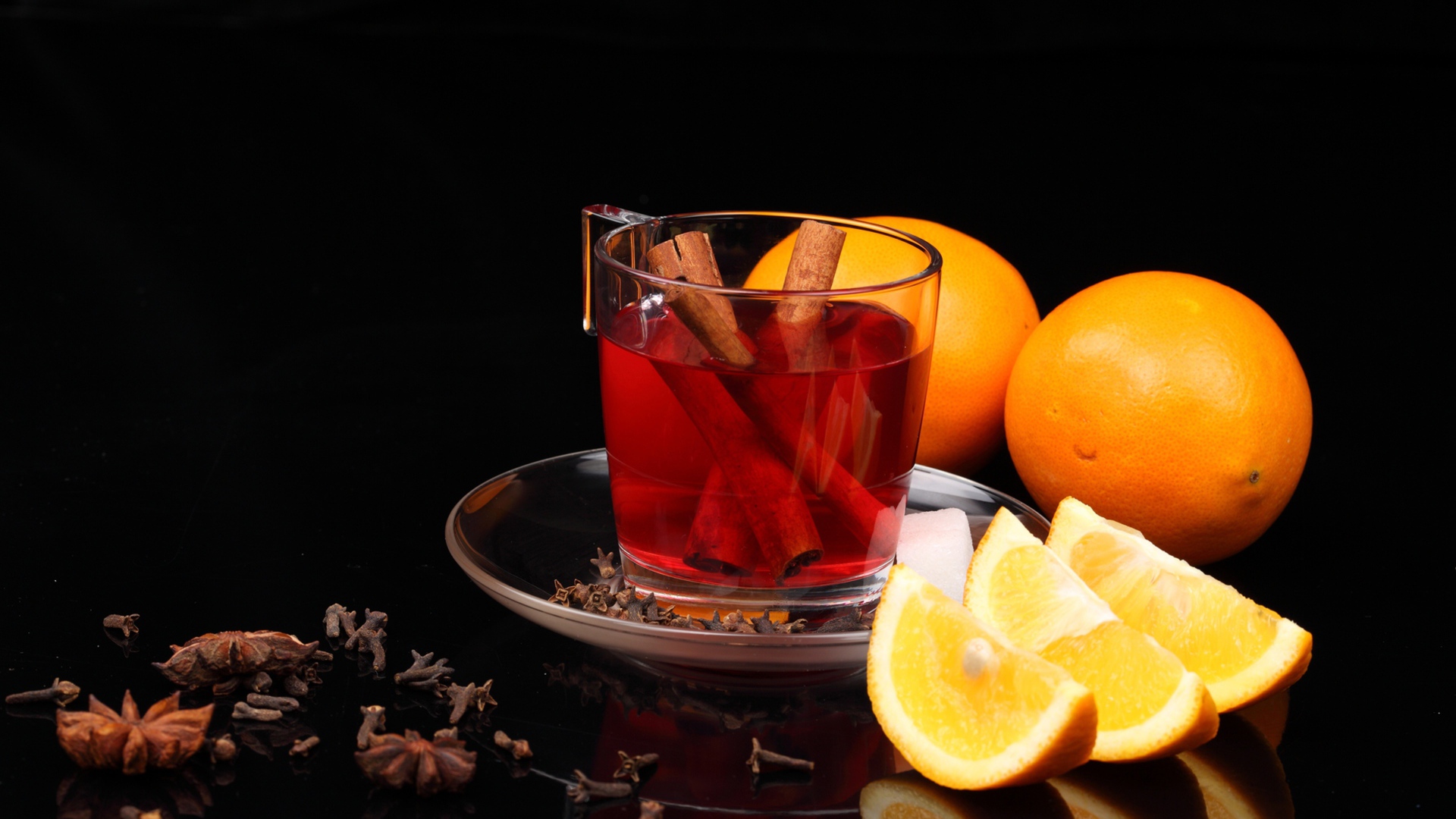 Чай с корицей и кусочками апельсина на черном фоне