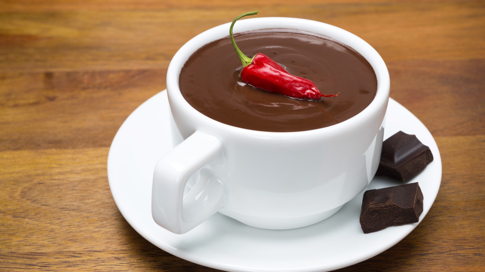 Белая чашка горячего шоколада с красным перцем