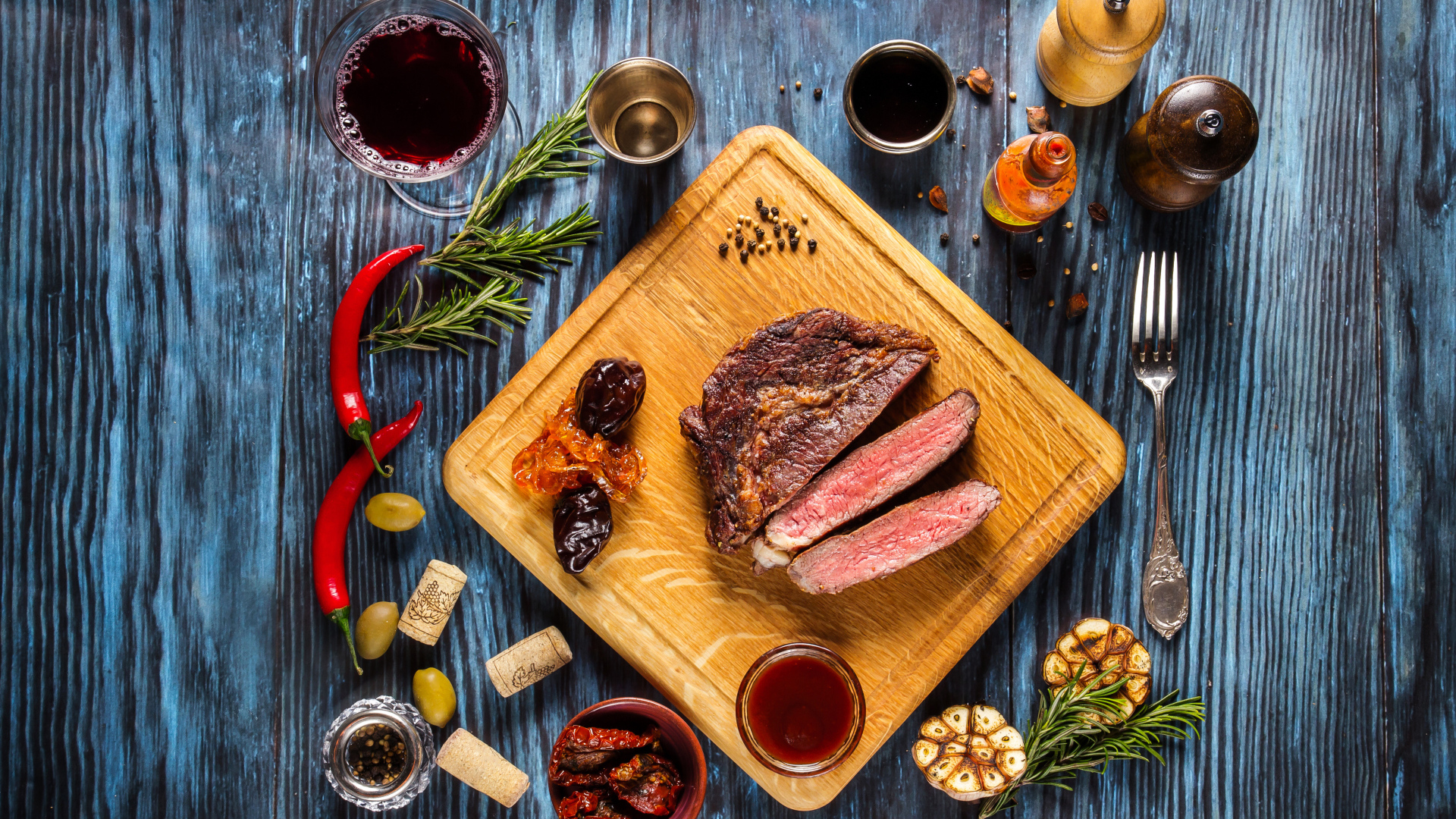 Кусок мяса на столе со специями и стаканом вина