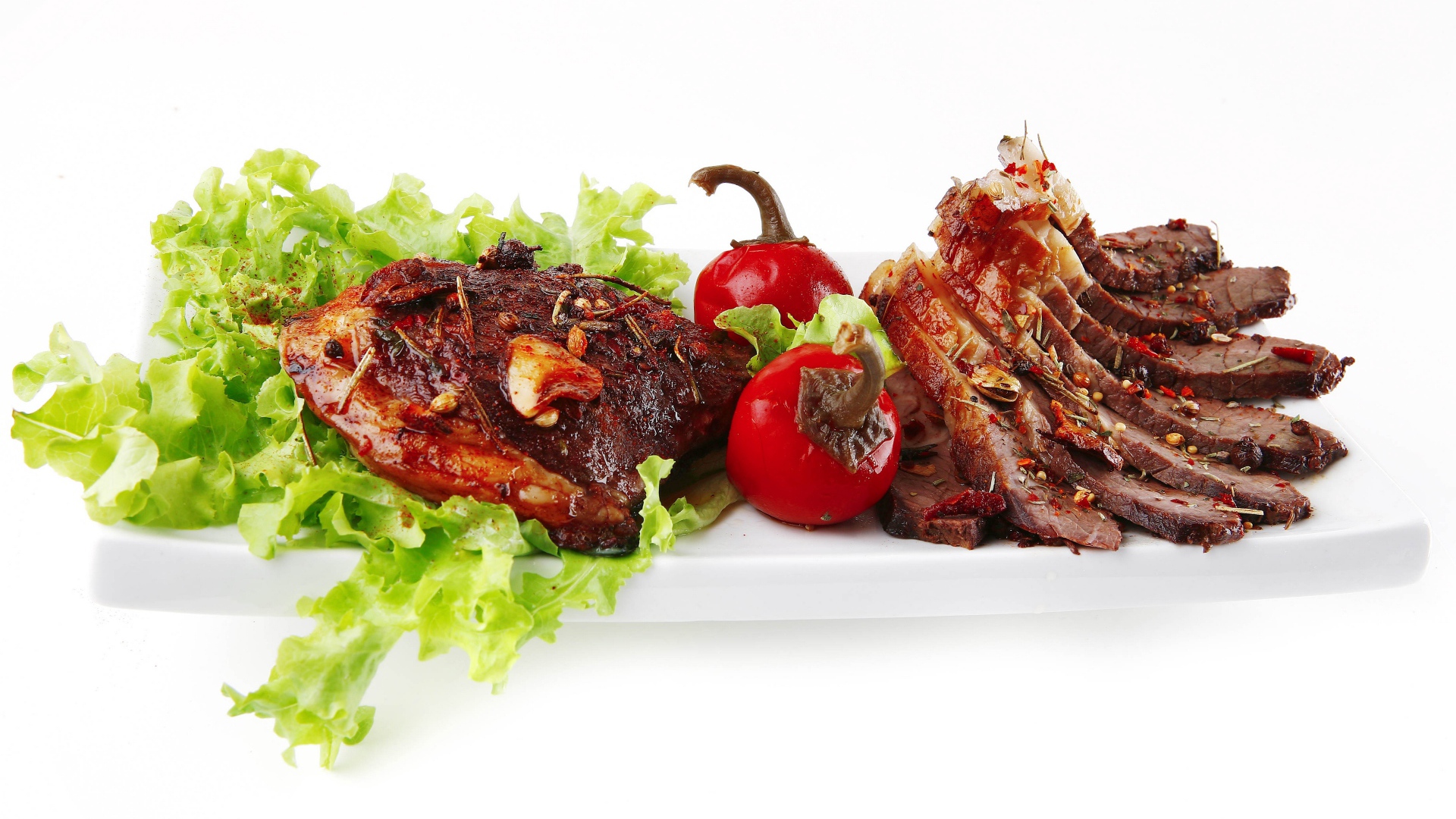 Мясо с листьями салата и красным перцем на белом фоне