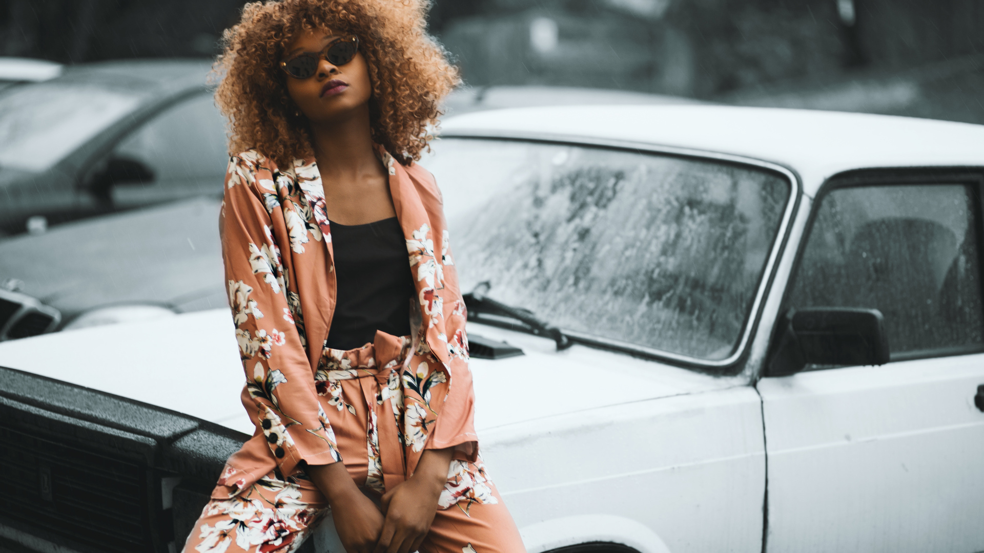 Красивая темнокожая девушка сидит на автомобиле 