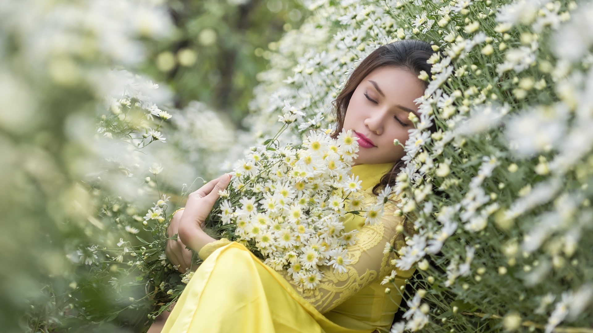 Молодая девушка лежит с букетом белых ромашек
