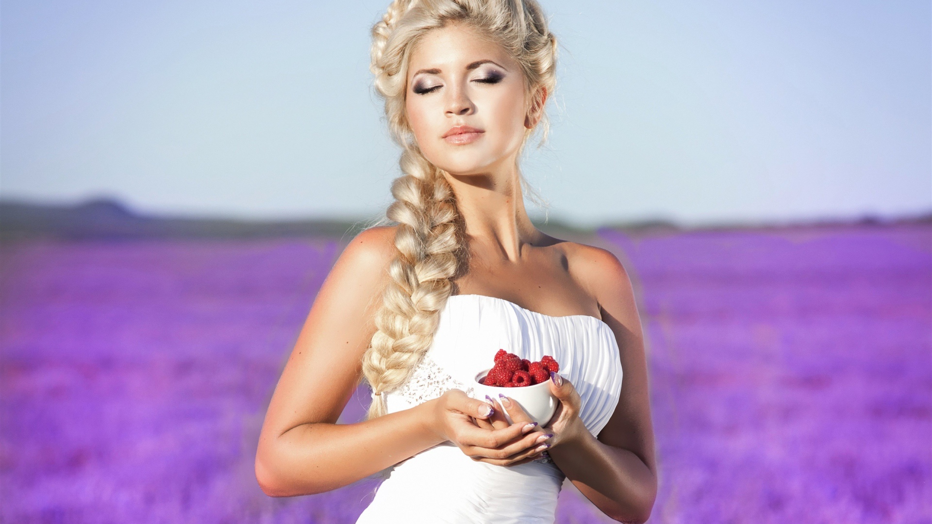 Красивая блондинка в белом платье с малиной на лавандовом поле