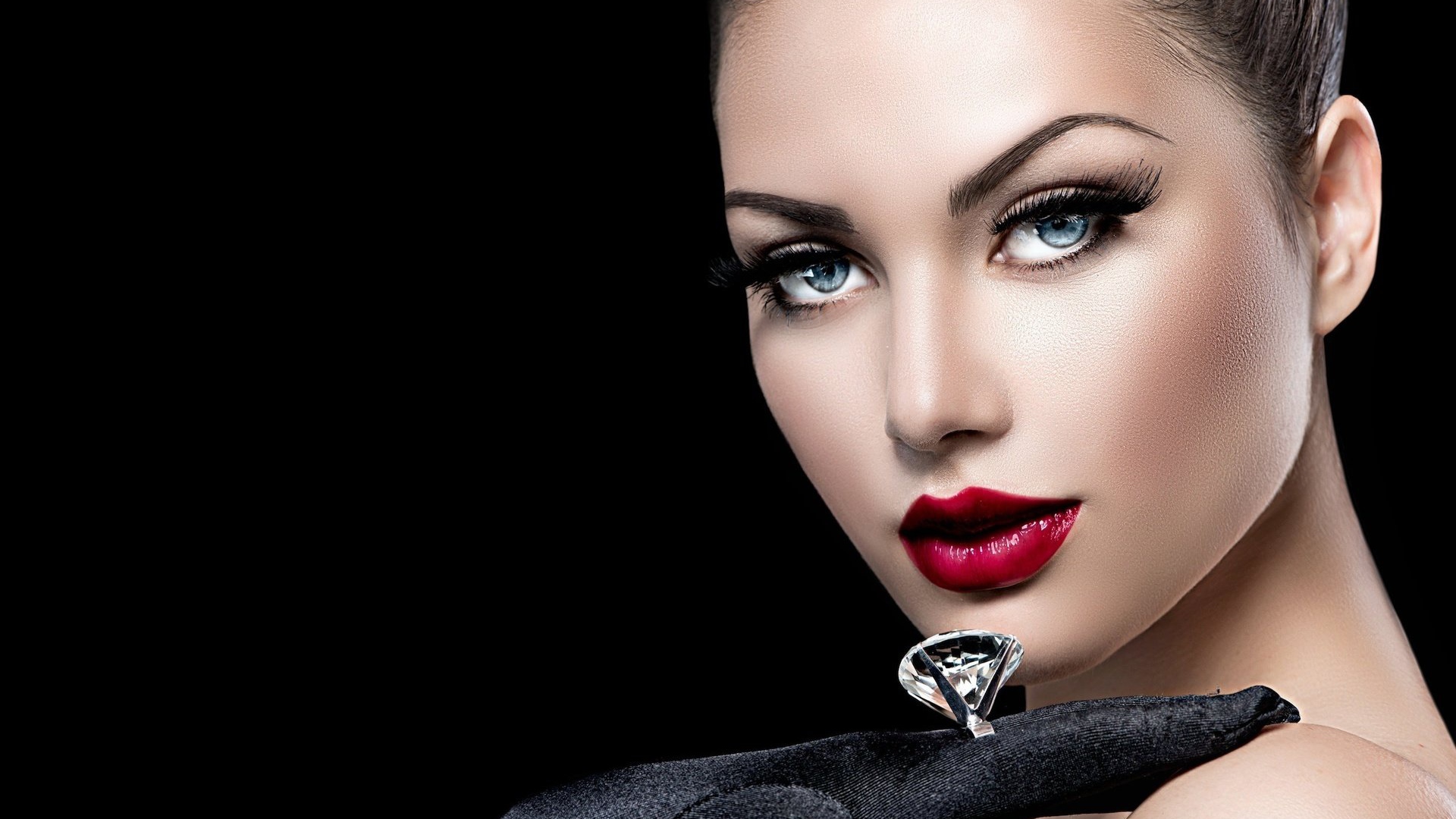 Красивая голубоглазая девушка с кольцом на пальце на черном фоне