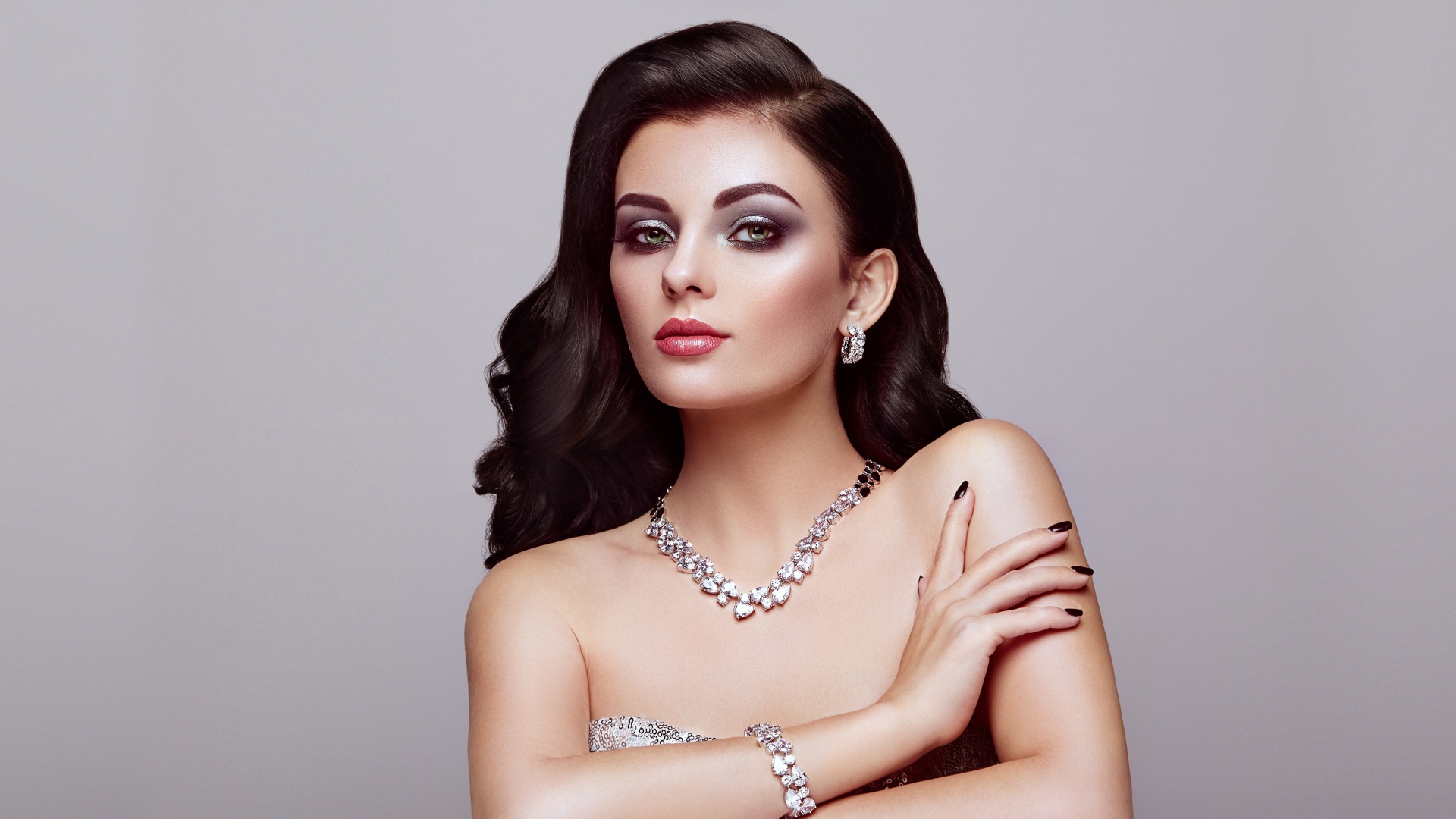 Красивая яркая брюнетка на сером фоне