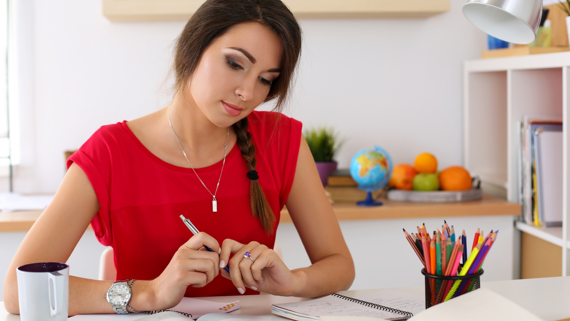 Красивая деловая девушка за столом с тетрадями