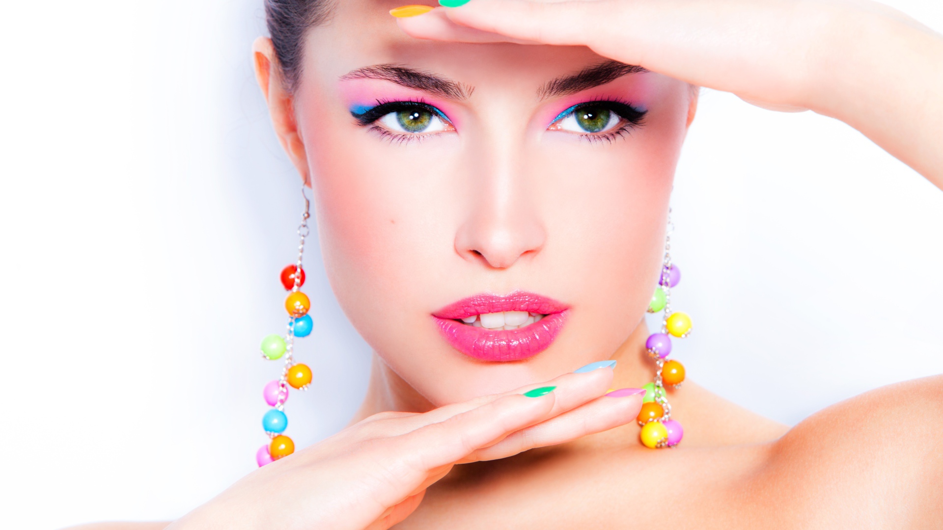 Красивая девушка с ярким макияжем и разноцветным маникюром на ногтях