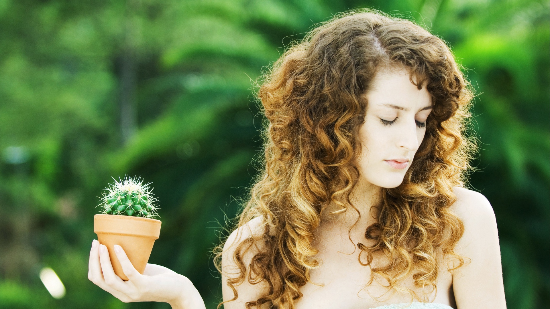 Красивая девушка с закрытыми глазами с кактусом в руке