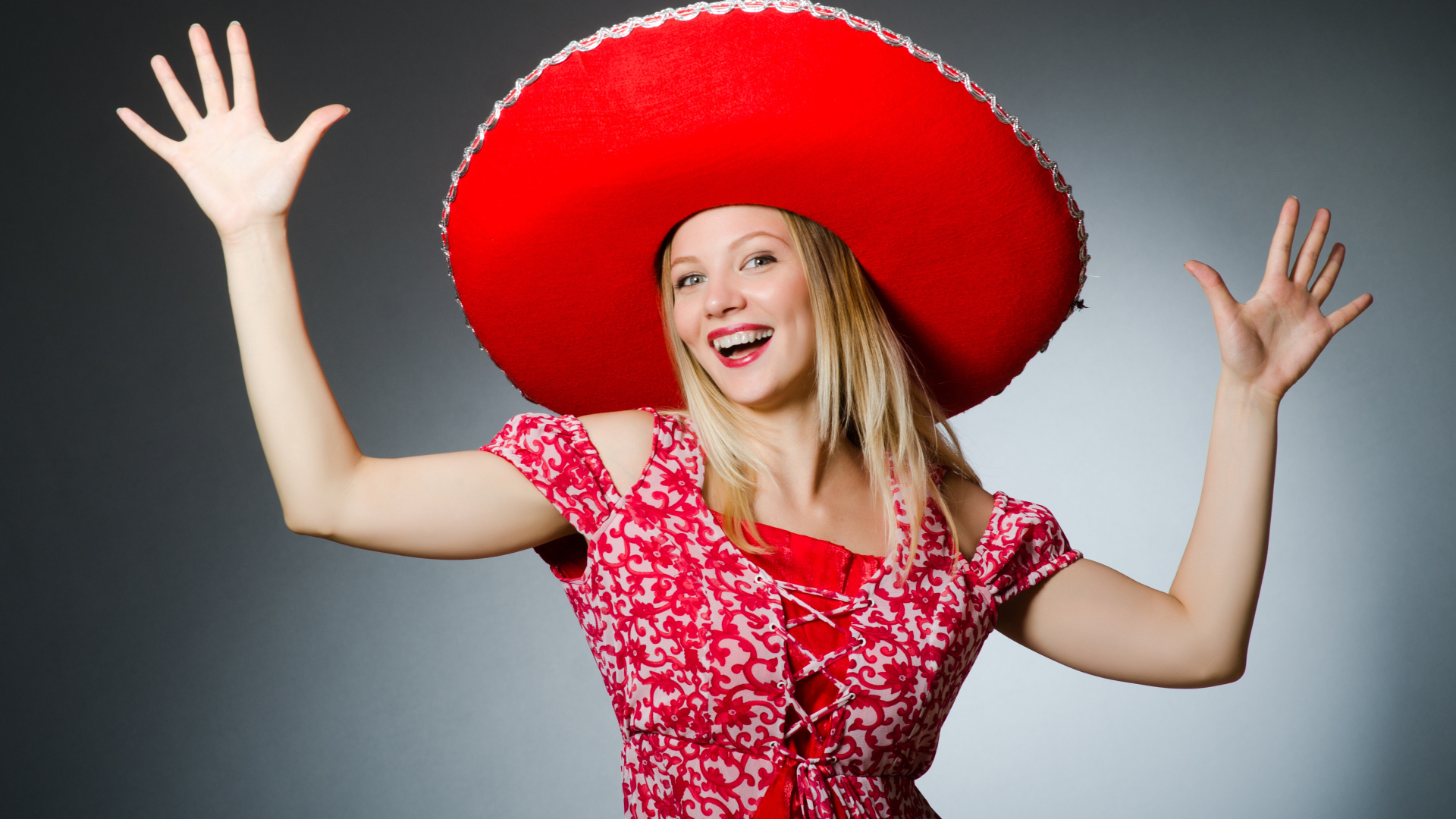 Красивая улыбающаяся блондинка в большой красной шляпе