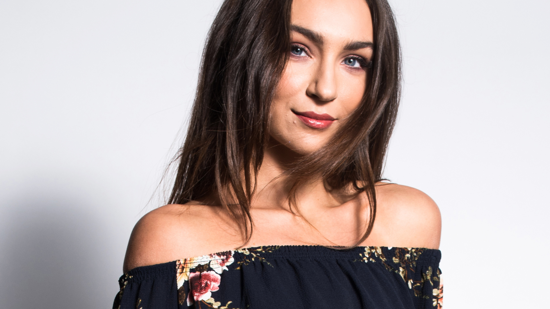 Красивая нежная голубоглазая брюнетка на сером фоне