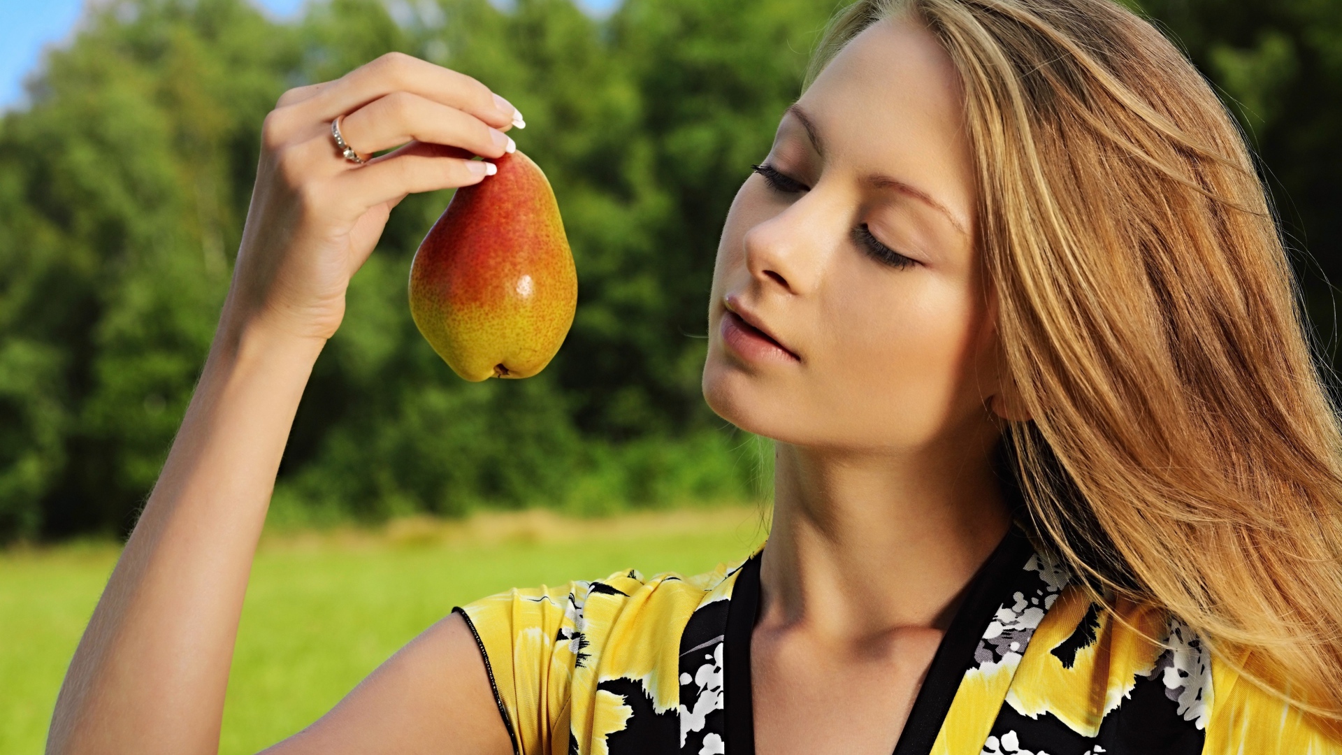 Красивая молодая девушка с грушей в руках