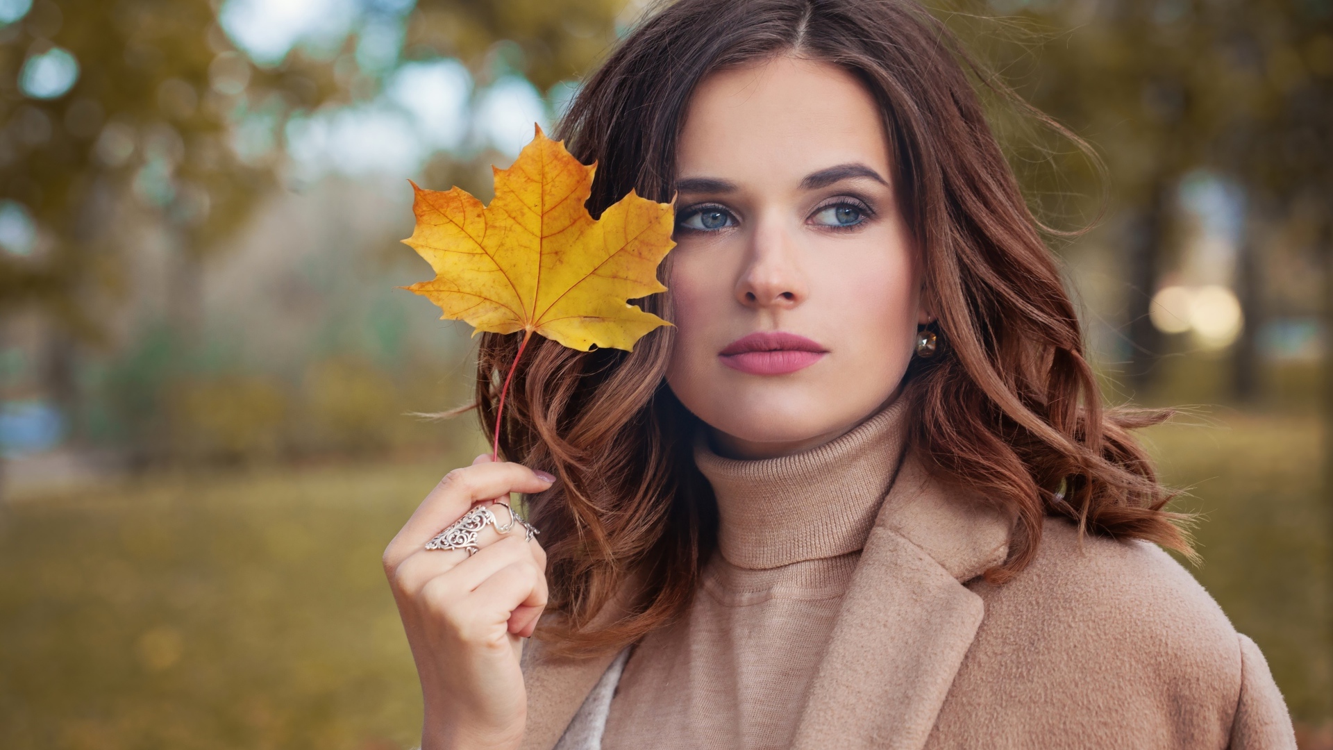 Красивая молодая девушка шатенка с желтым листом в руке