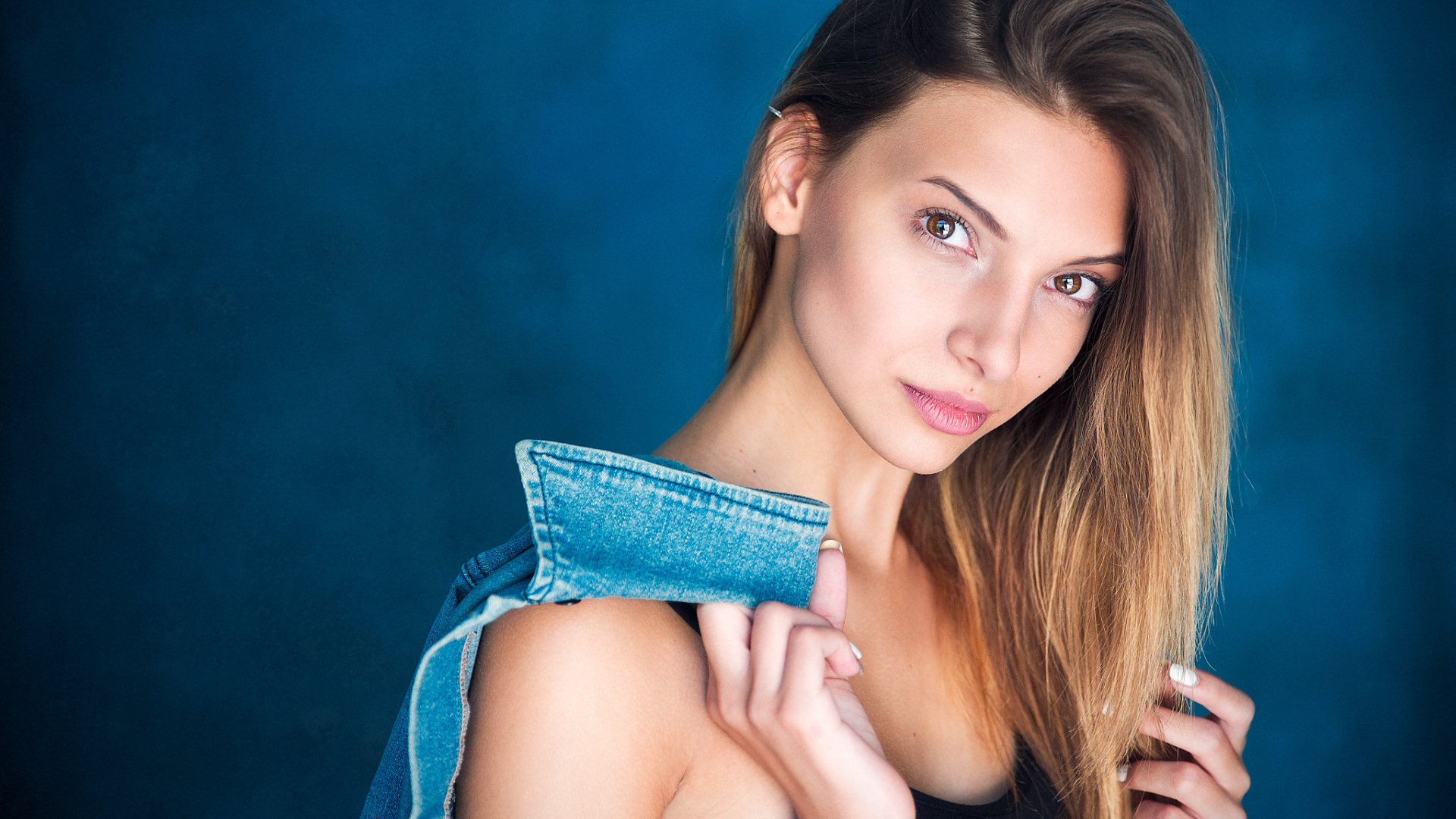 Кареглазая шатенка с джинсовой курткой в руке