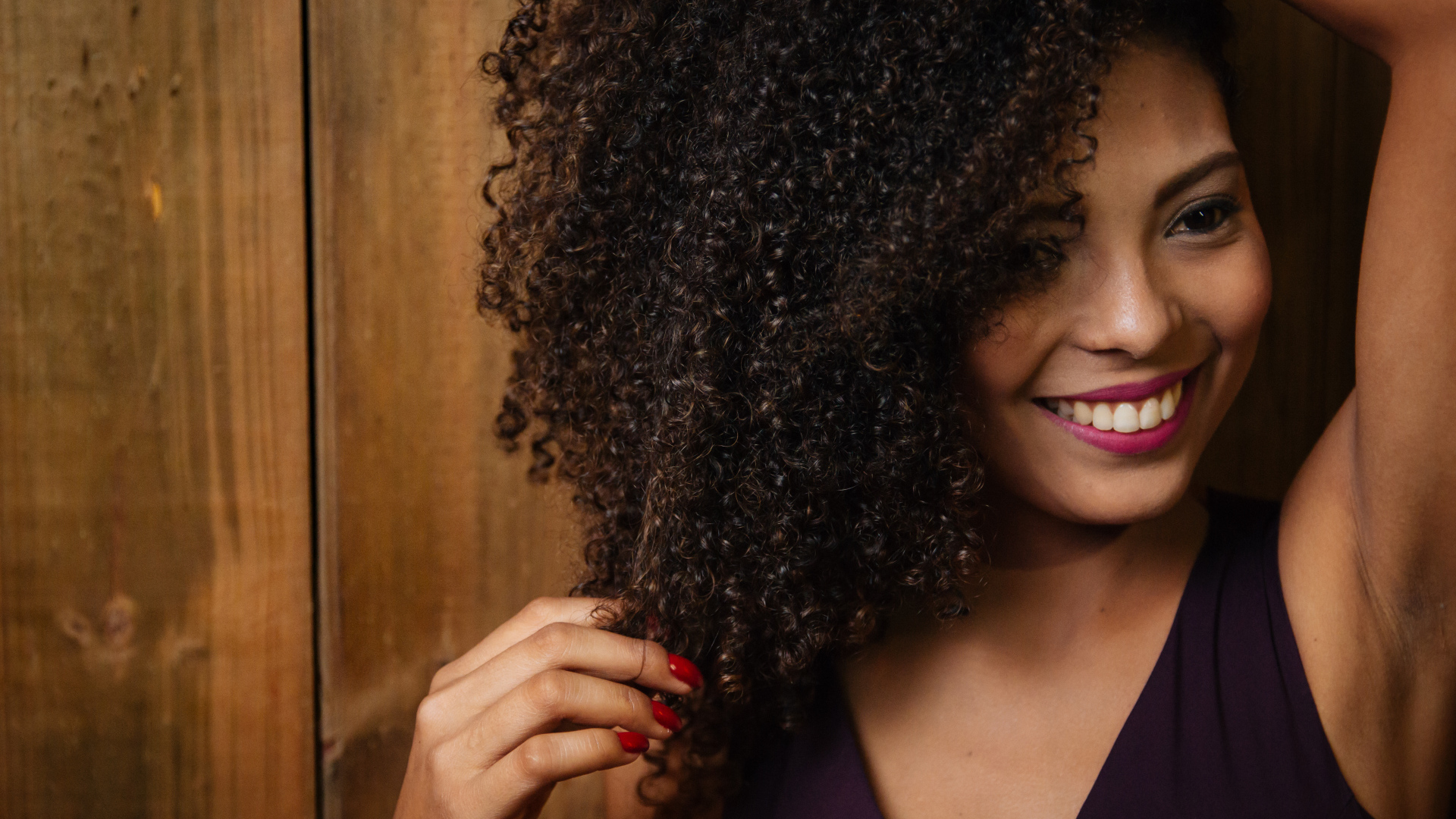 Кучерявая темнокожая девушка с красивой улыбкой 