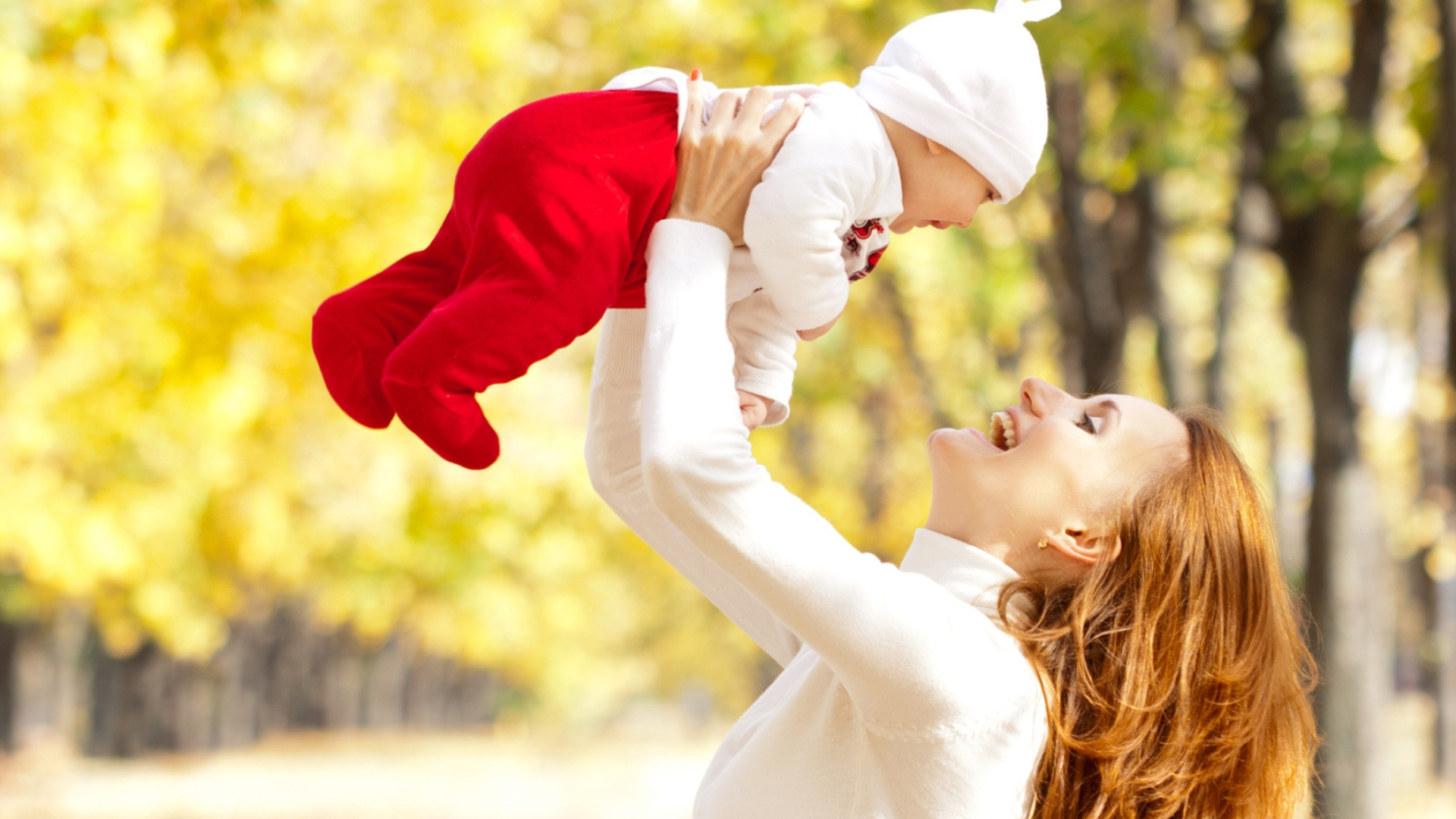 Счастливая девушка с младенцем на руках