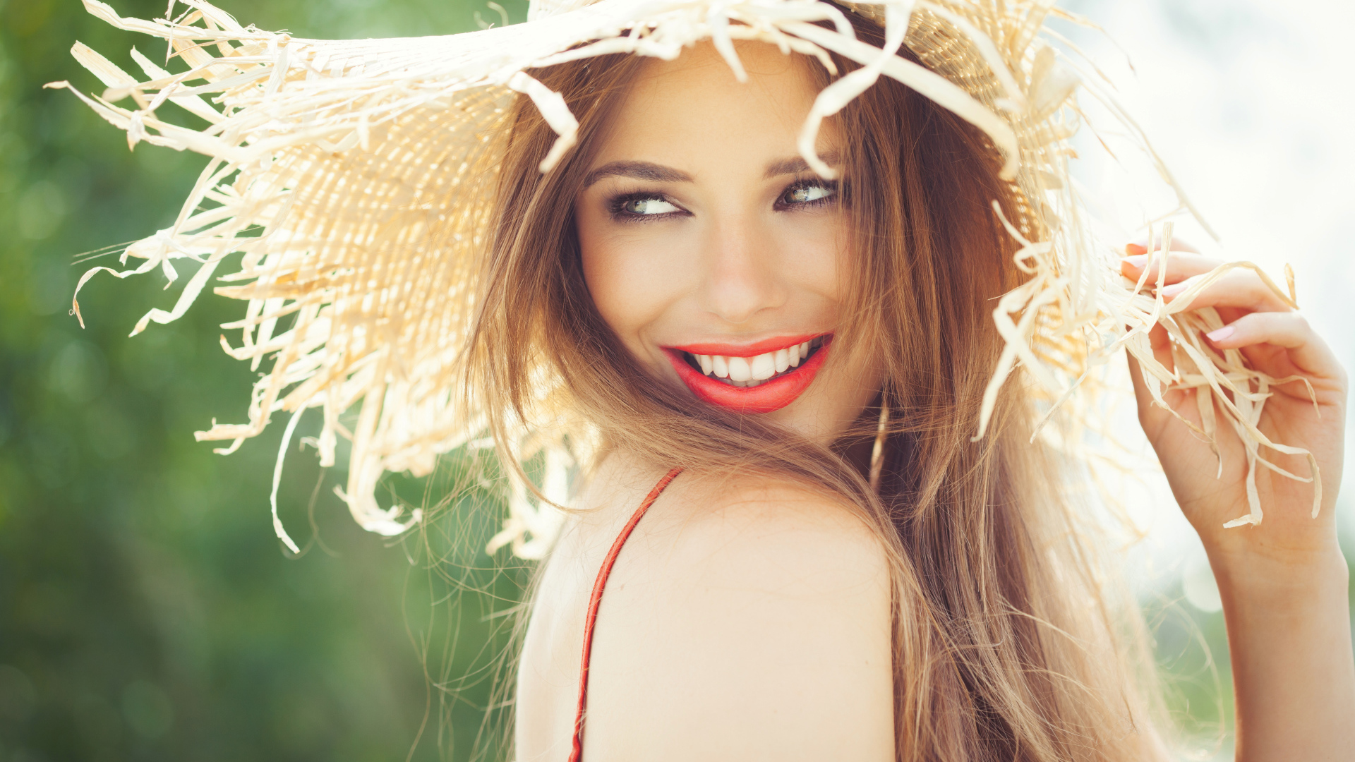 Улыбающаяся девушка в соломенной шляпе летом