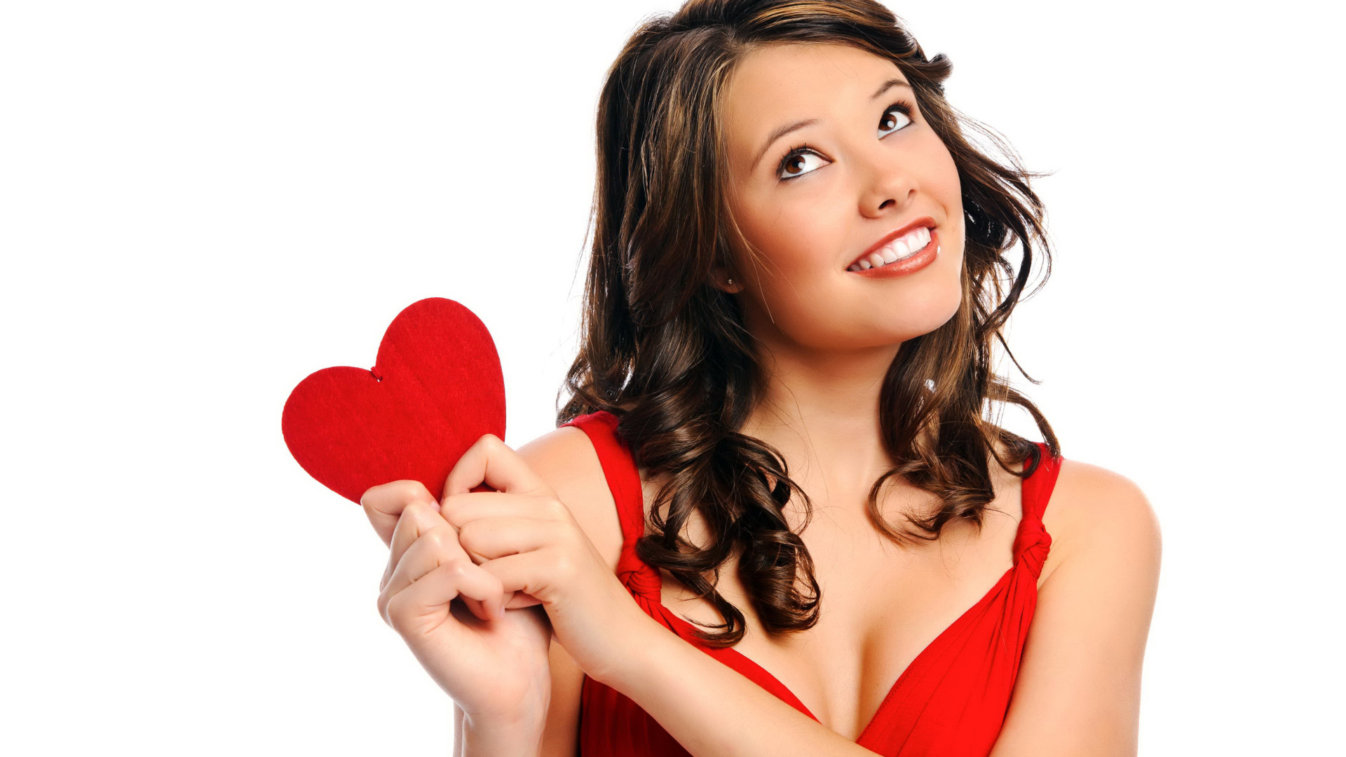 Улыбающаяся девушка с красным сердечком в руках на белом фоне