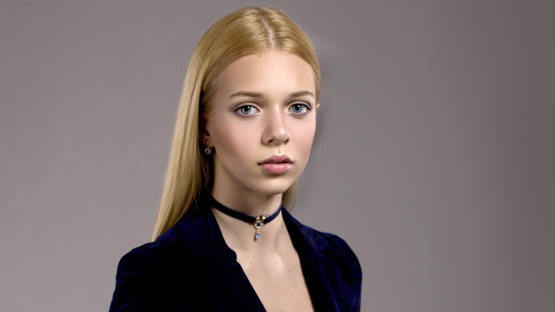 Нежная голубоглазая девушка с украшением на шее 