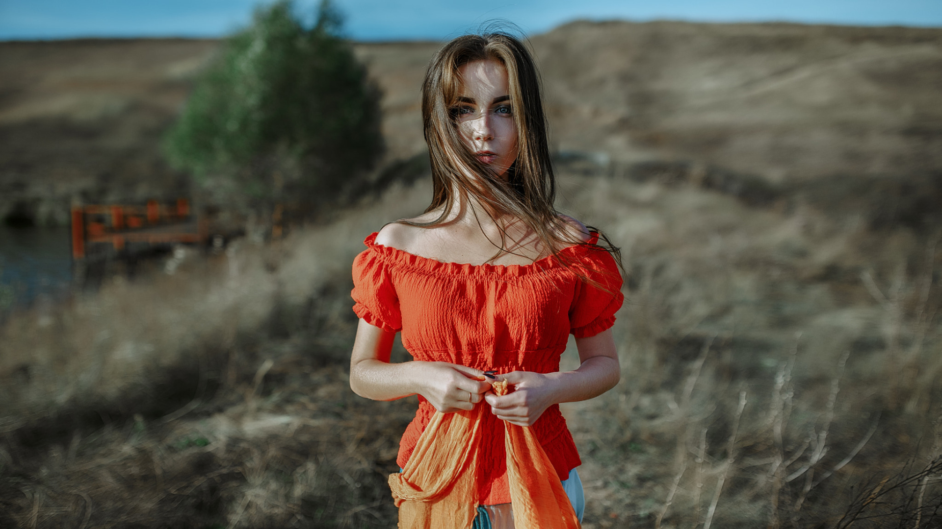 Ветер развивает волосы красивой девушке шатенке 