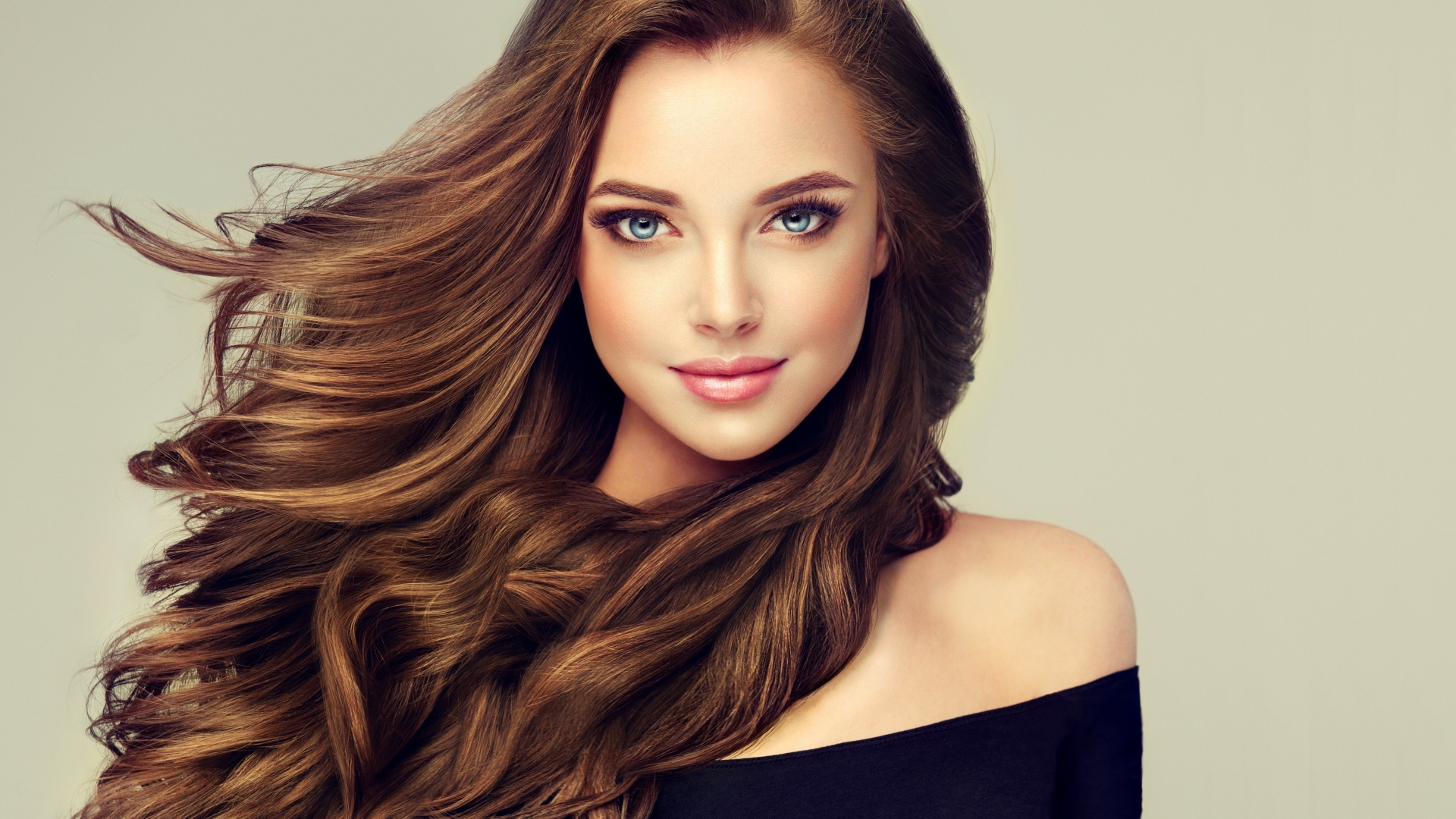 Молодая голубоглазая девушка с красивыми длинными волосами