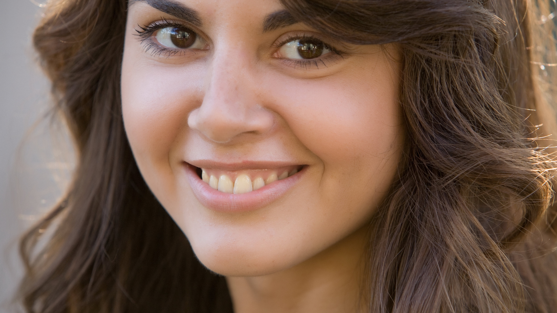 Молодая кареглазая брюнетка с очаровательной улыбкой