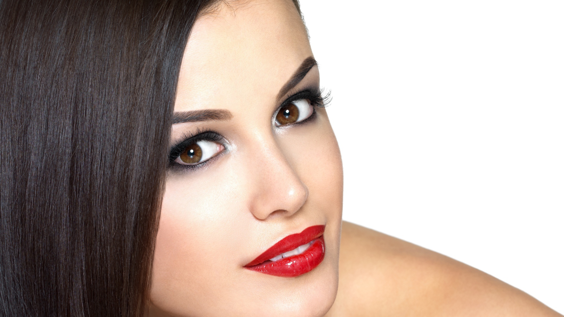 Молодая кареглазая брюнетка с красными губами на белом фоне