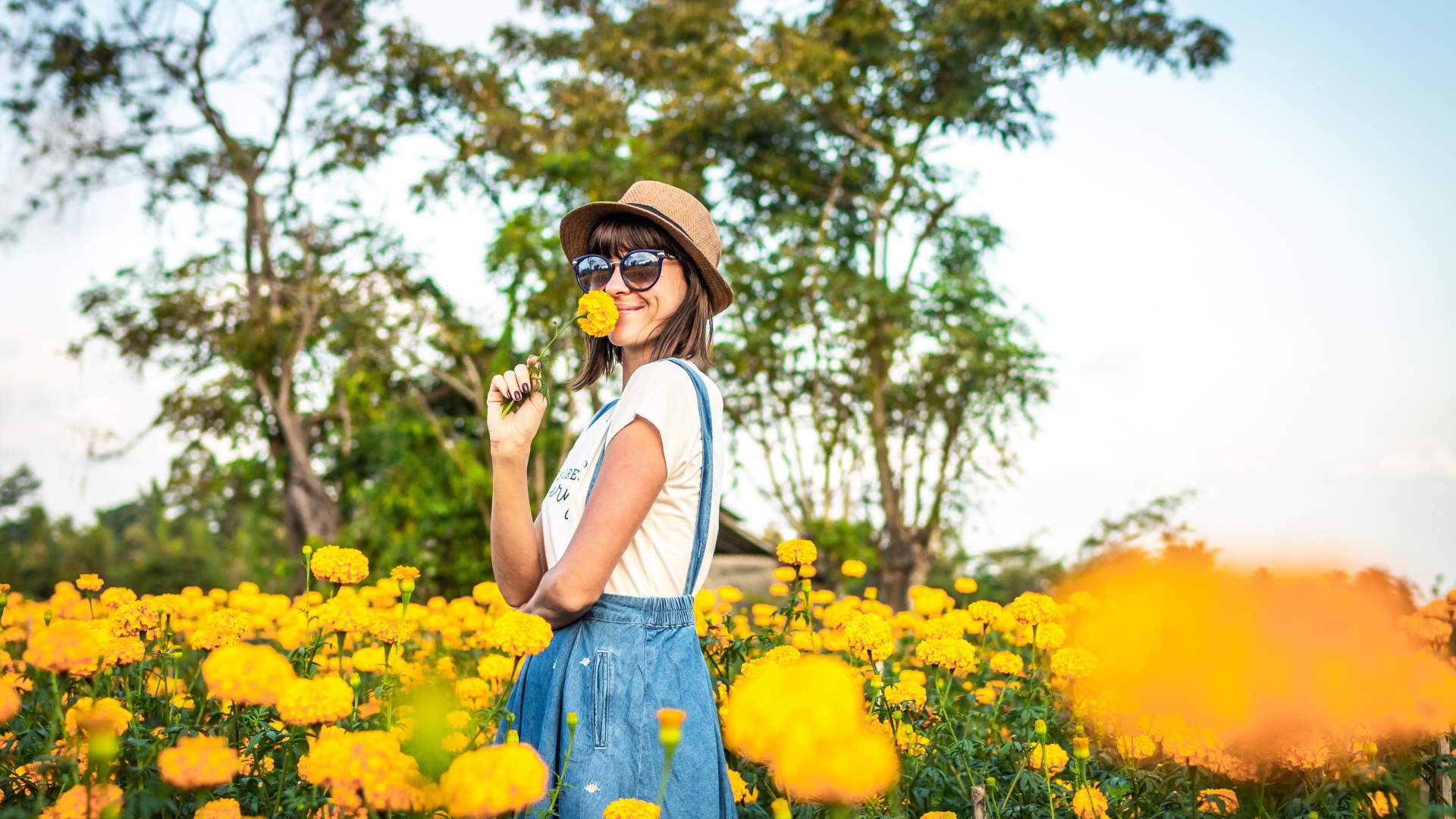 Молодая девушка в солнечных очках в желтых цветах 