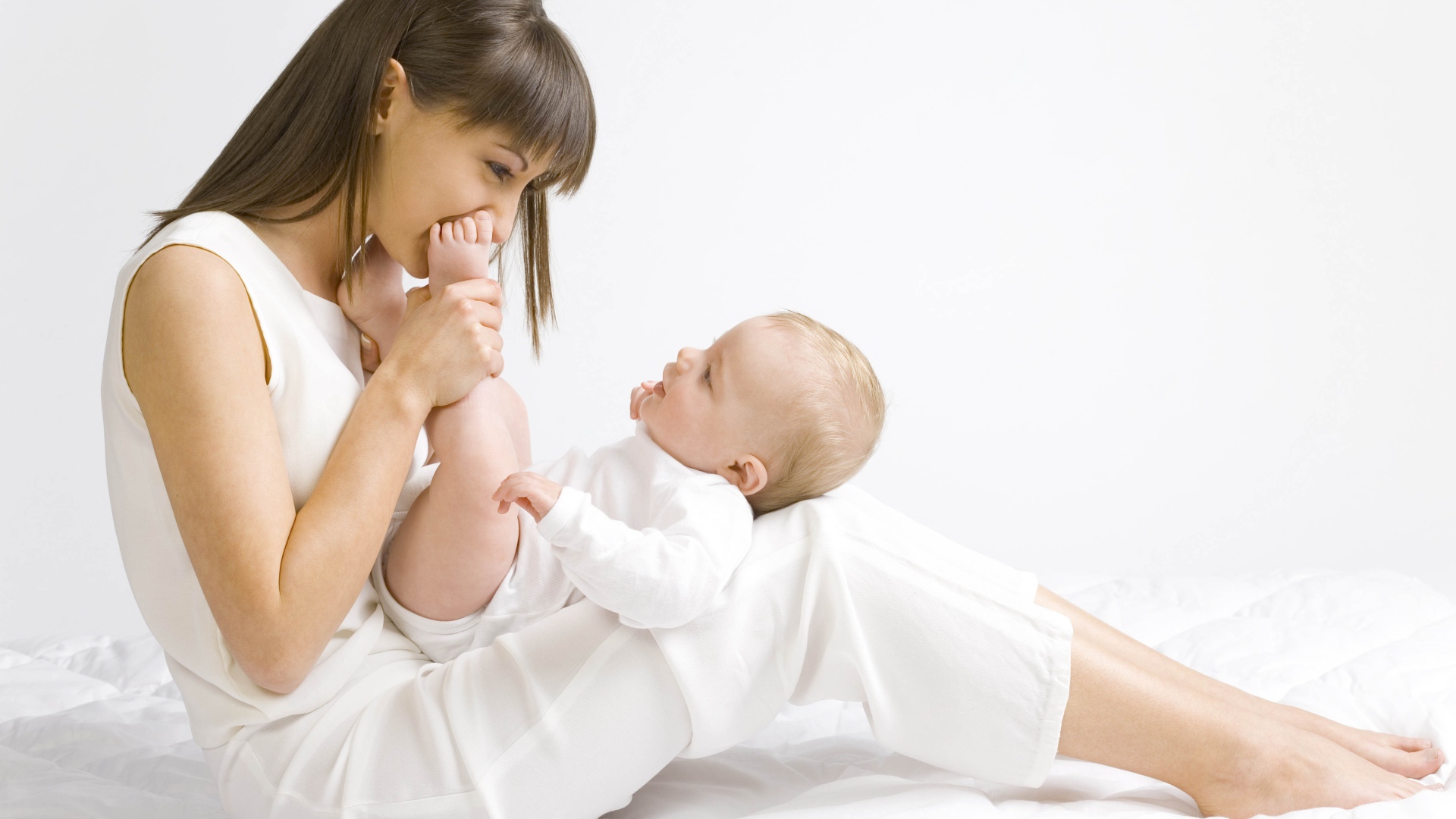 Молодая девушка в белом с младенцем