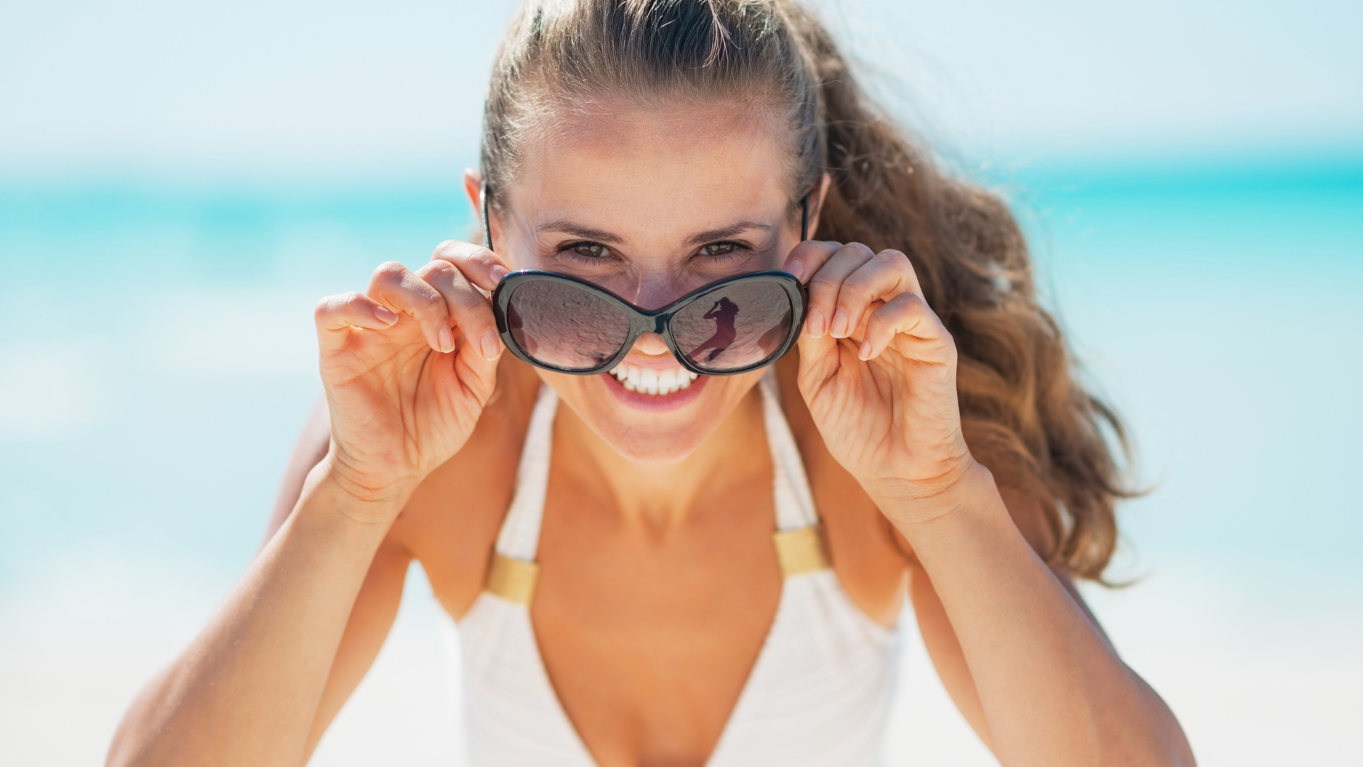 Молодая улыбающаяся девушка в солнечных очках 