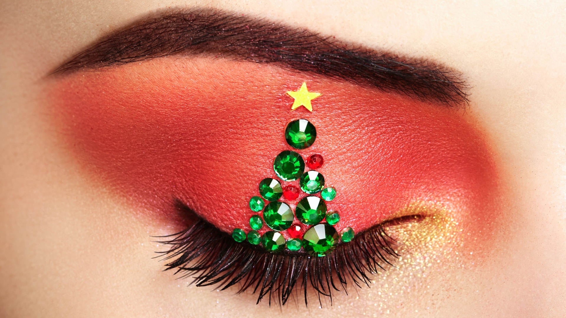 Christmas tree from rhinestones on the eyelid of the girl