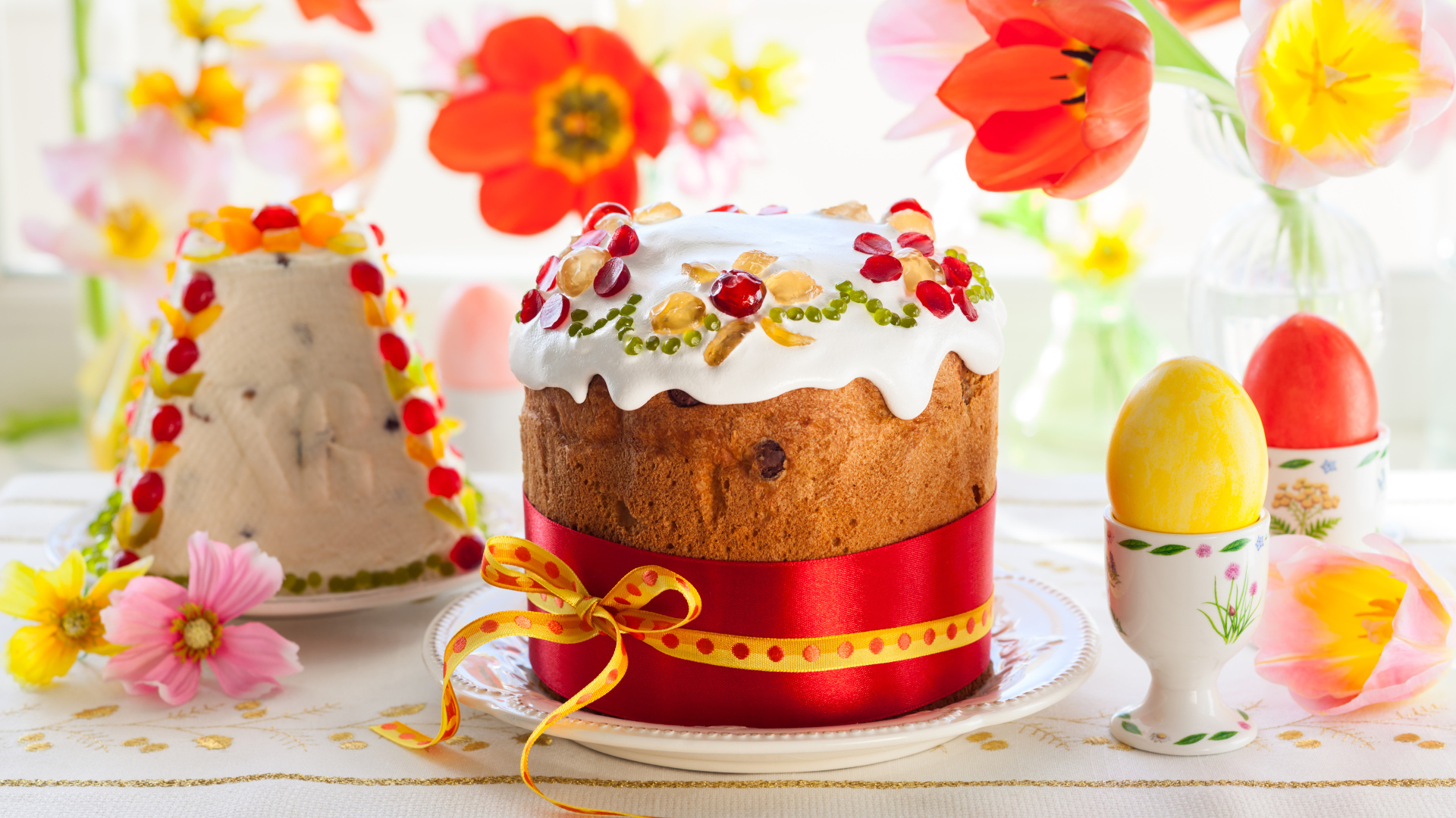 Красивые пасхальные куличи на столе с цветами и яйцами