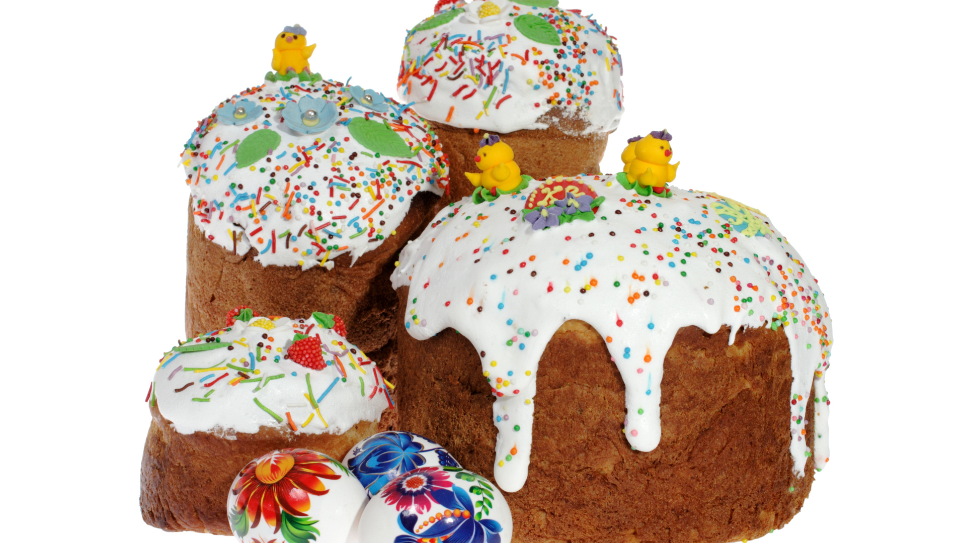 Пасхальные куличи с сахарными цыплятами и расписанными яйцами на белом фоне