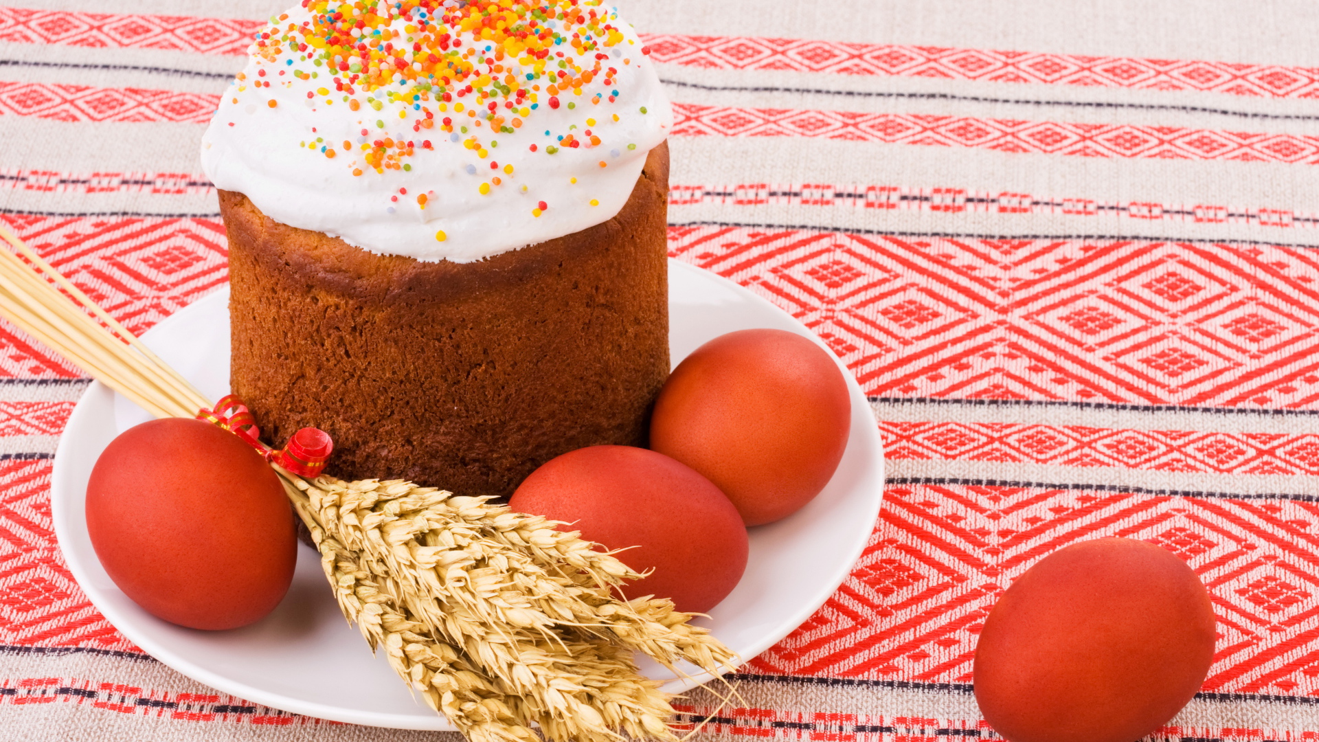 Пасха с крашеными яйцами и колосьями пшеницы на столе с красивой скатертью