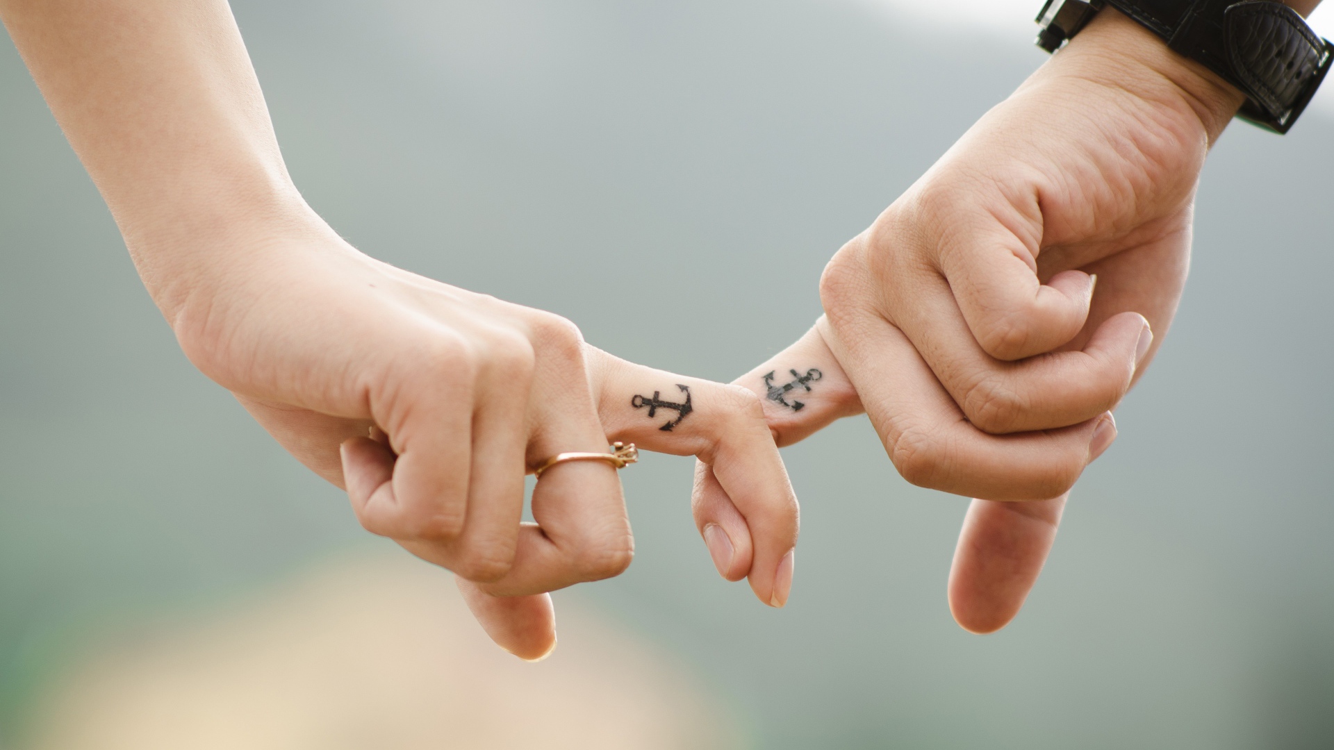 Руки влюбленной пары с татуировками на руках 