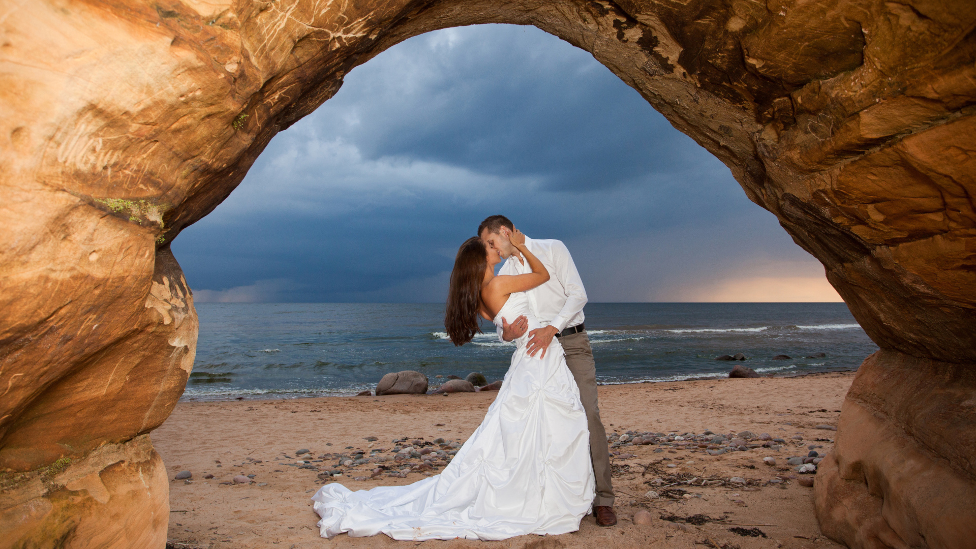 Поцелуй жениха и невесты на фоне моря