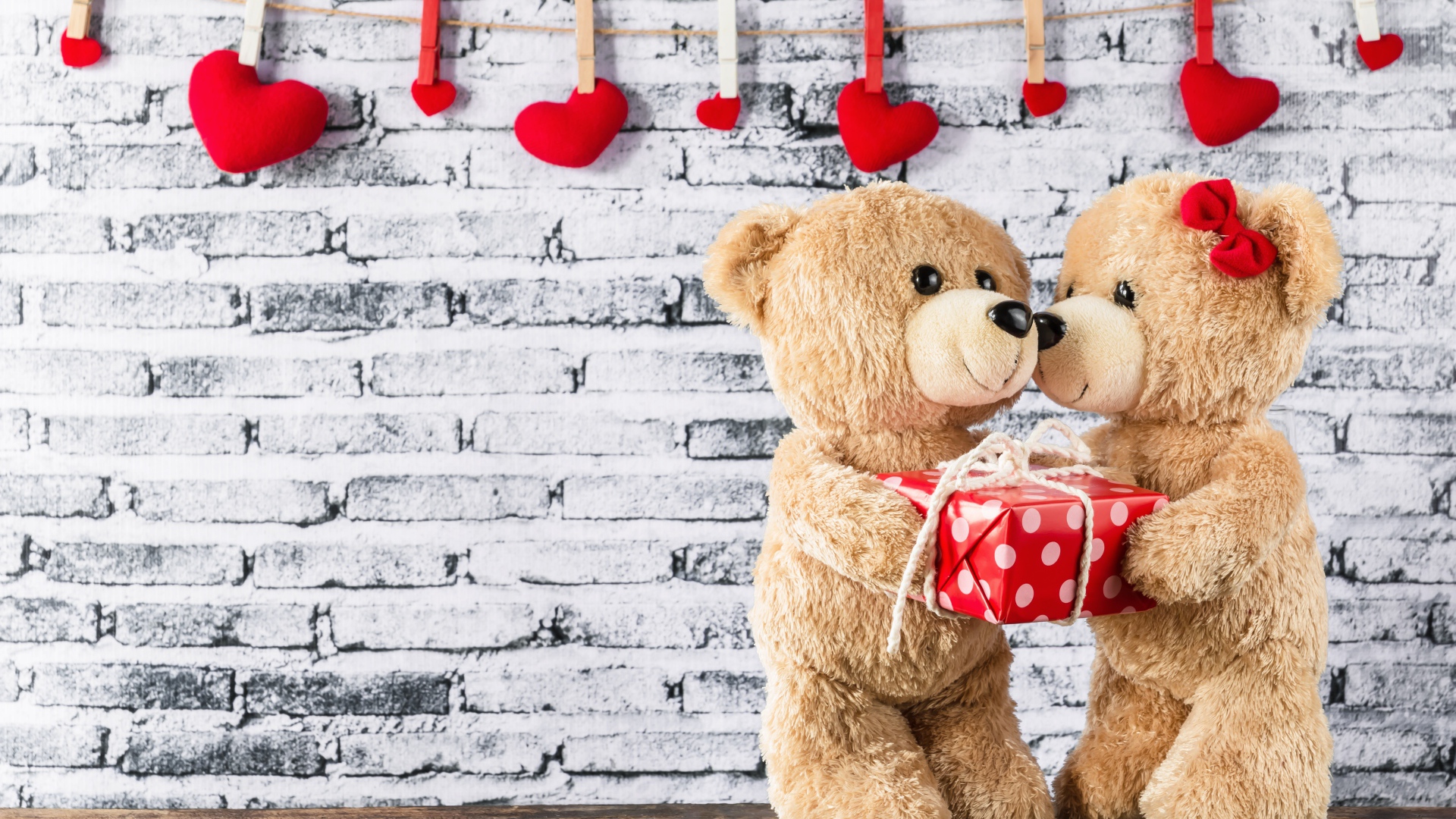 Влюбленные плюшевые мишки на фоне стены с сердечками 