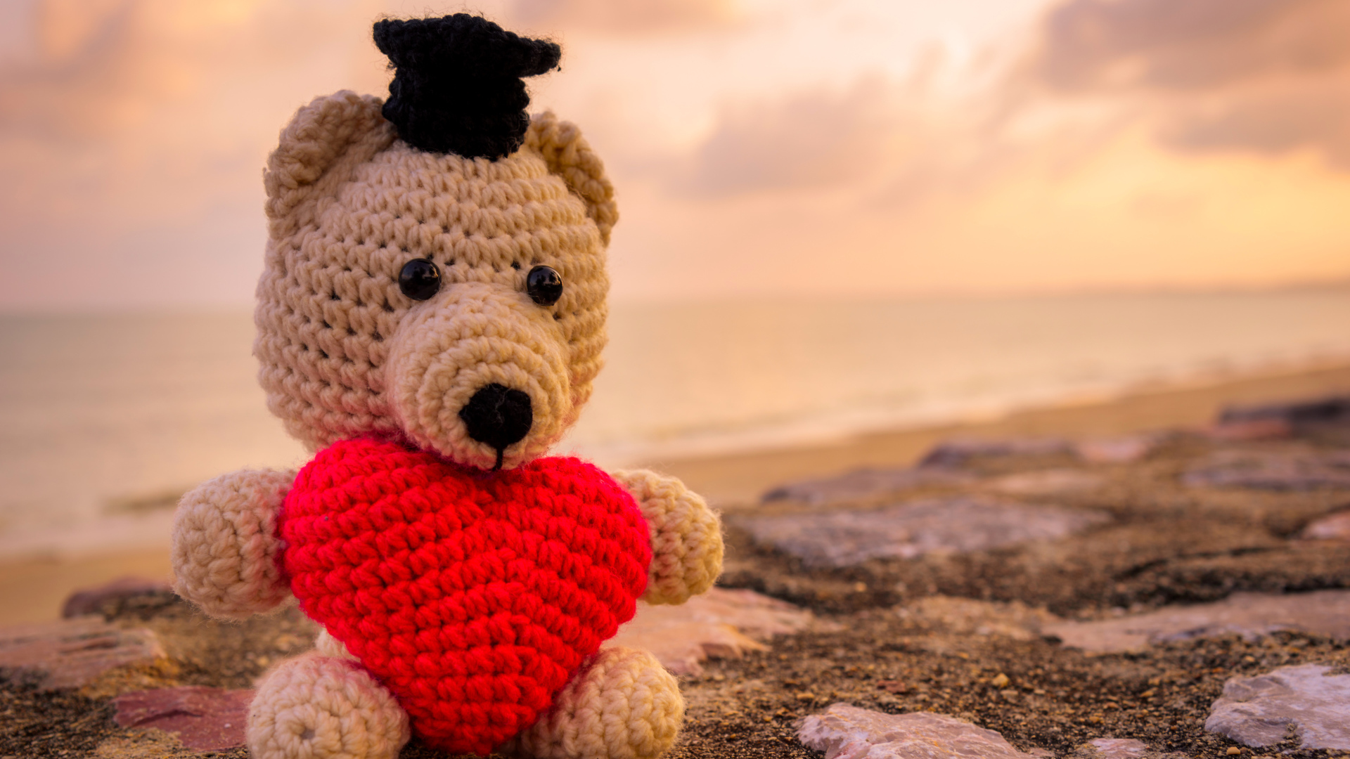 Игрушечный медведь с красным сердцем на фоне неба