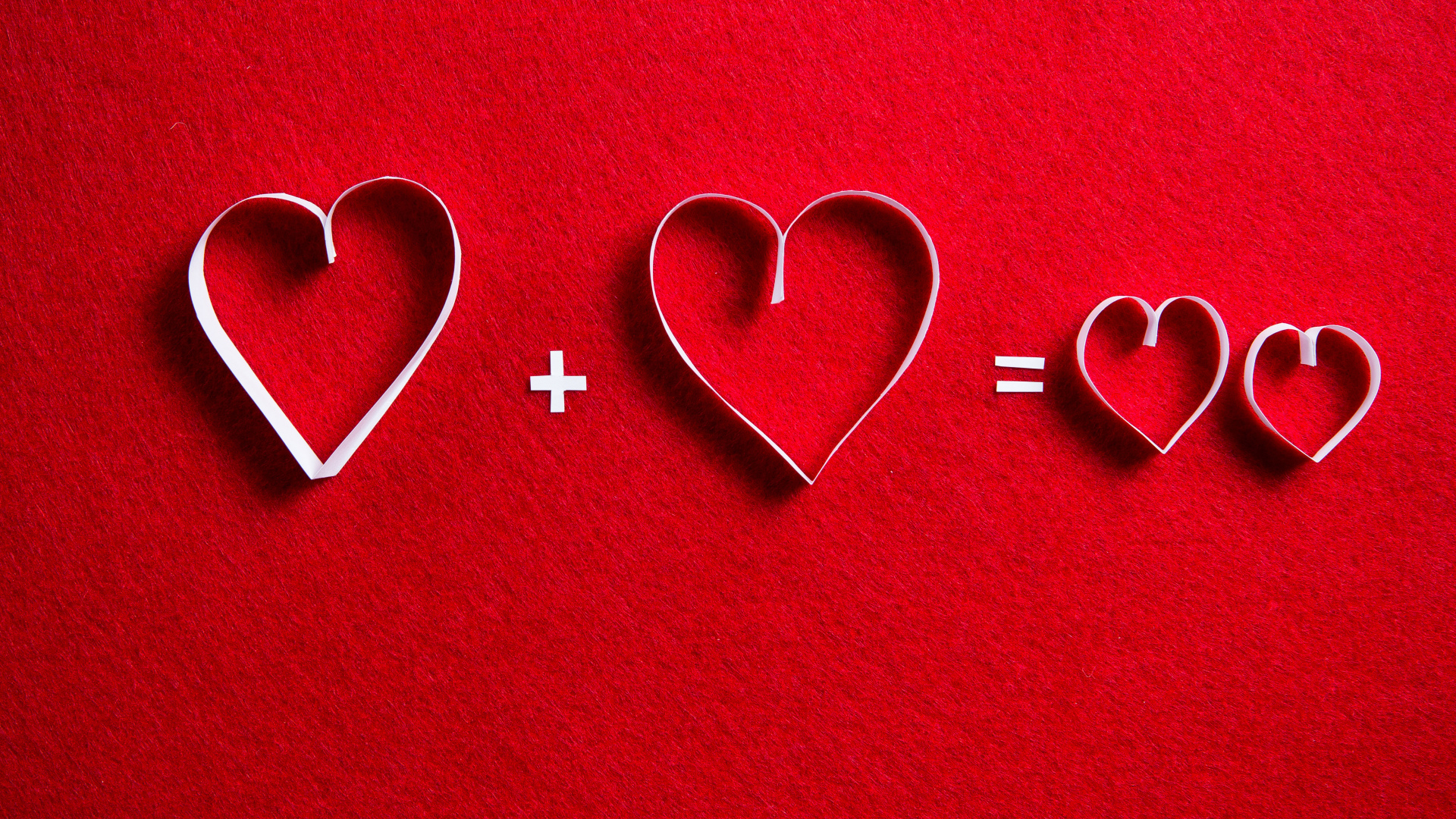 Белые бумажные сердечки на красном фоне