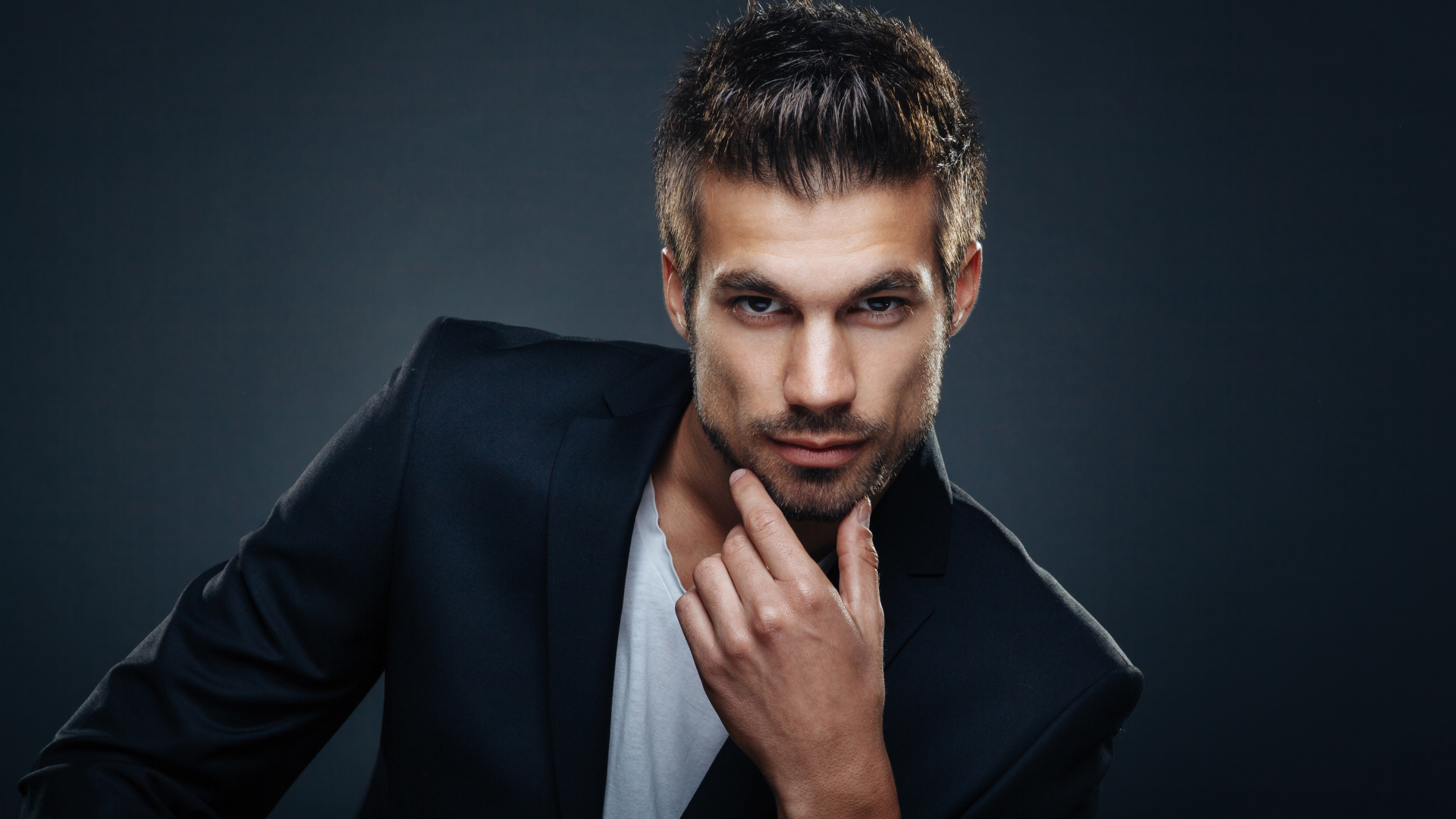 Красивый стильный мужчина в костюме на сером фоне