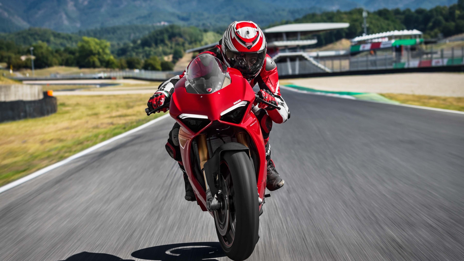 Красный мотоцикл  Ducati Panigale V4 S, 2018 на трассе с мотогонщиком