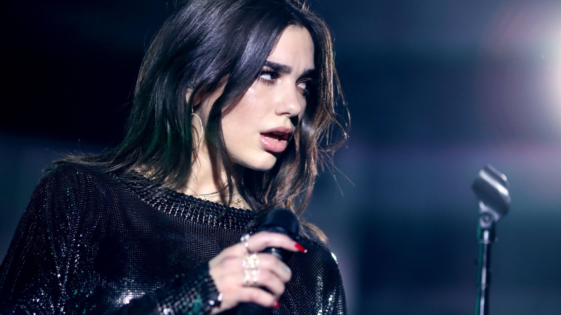 Британская певица Дуа Липа с микрофоном в руках