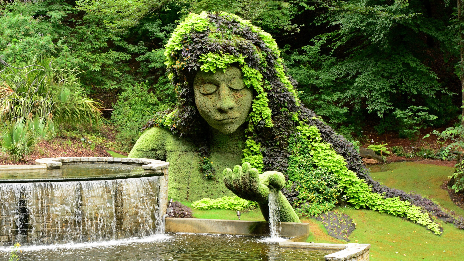 Красивый водопад в парке со скульптурой 
