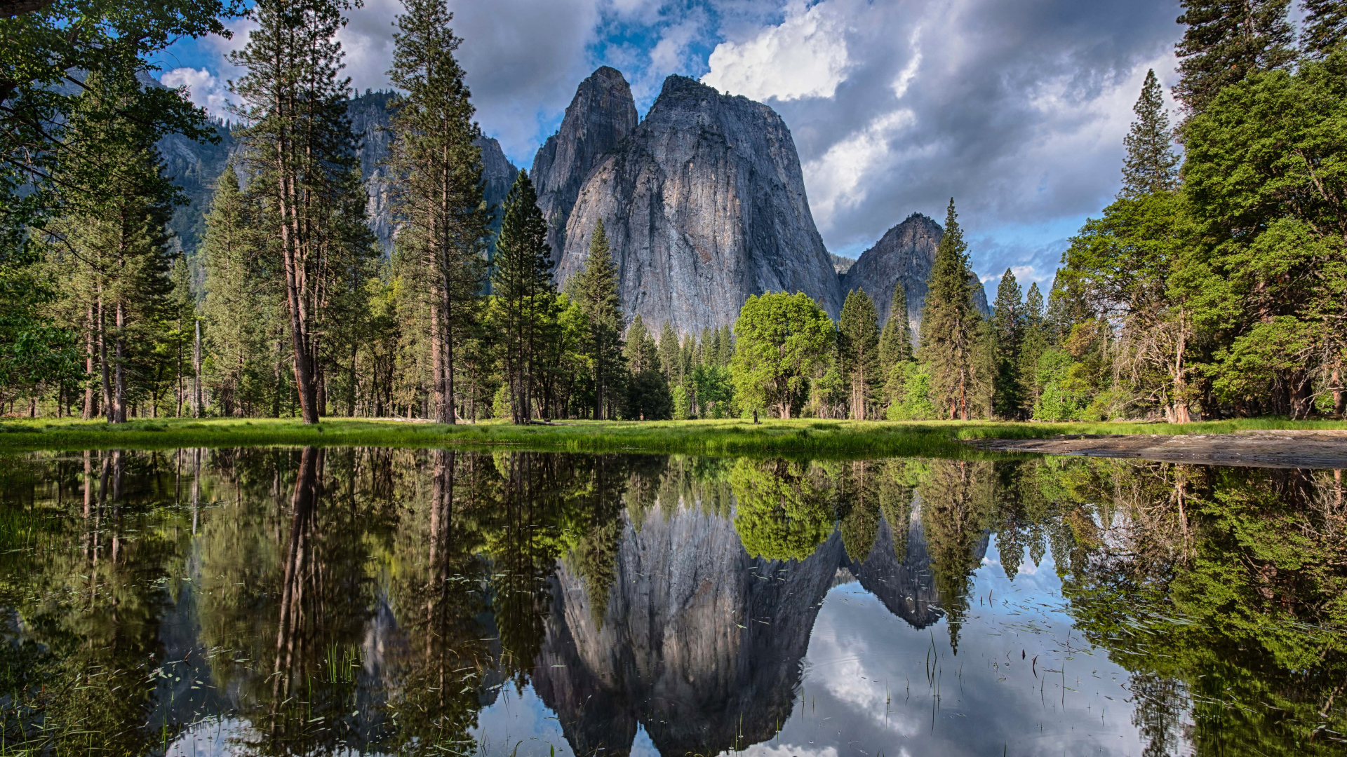 Каменные скалы и лес отражаются в воде 