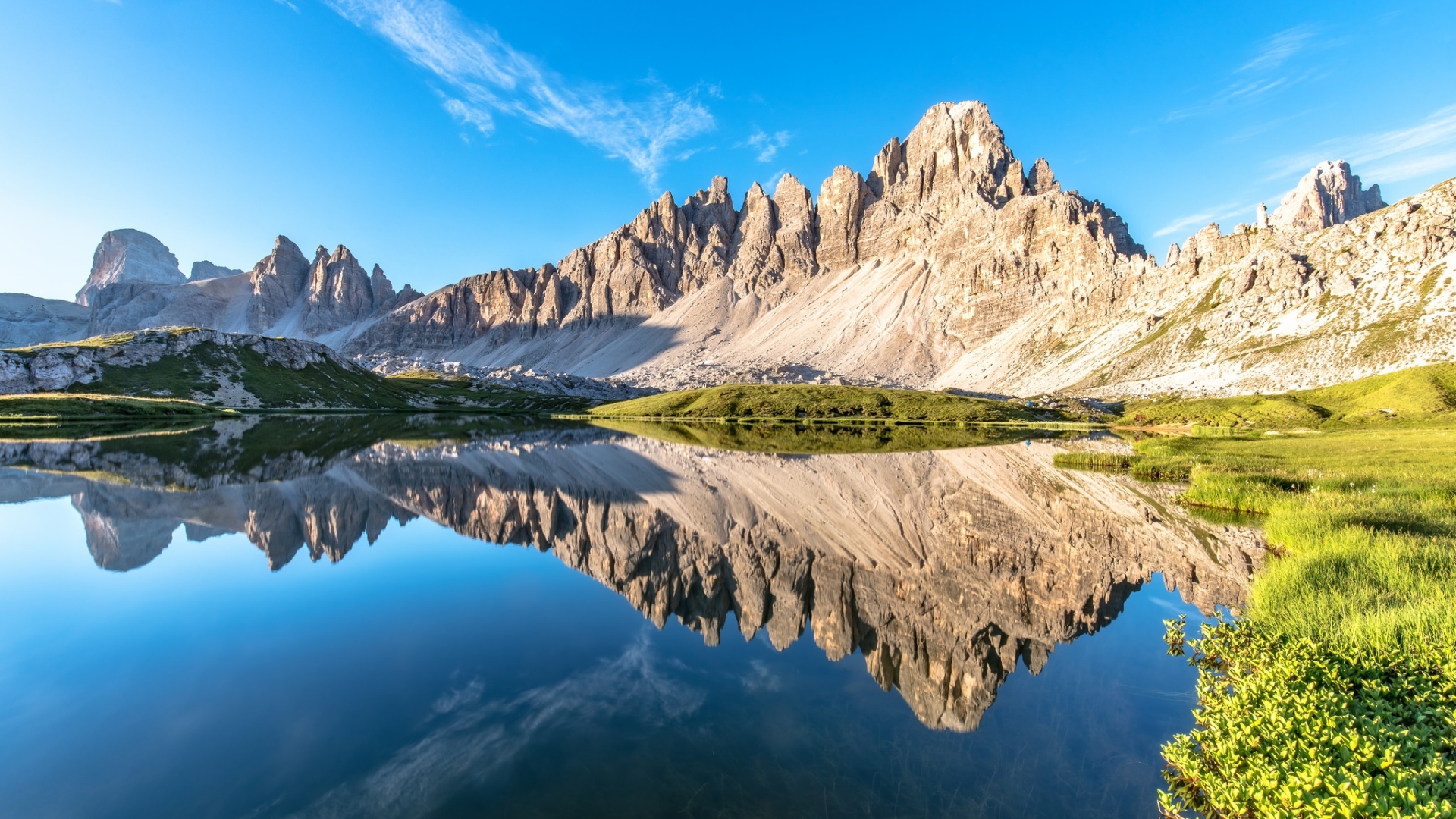 Горы и голубое небо отражаются в чистой воде 