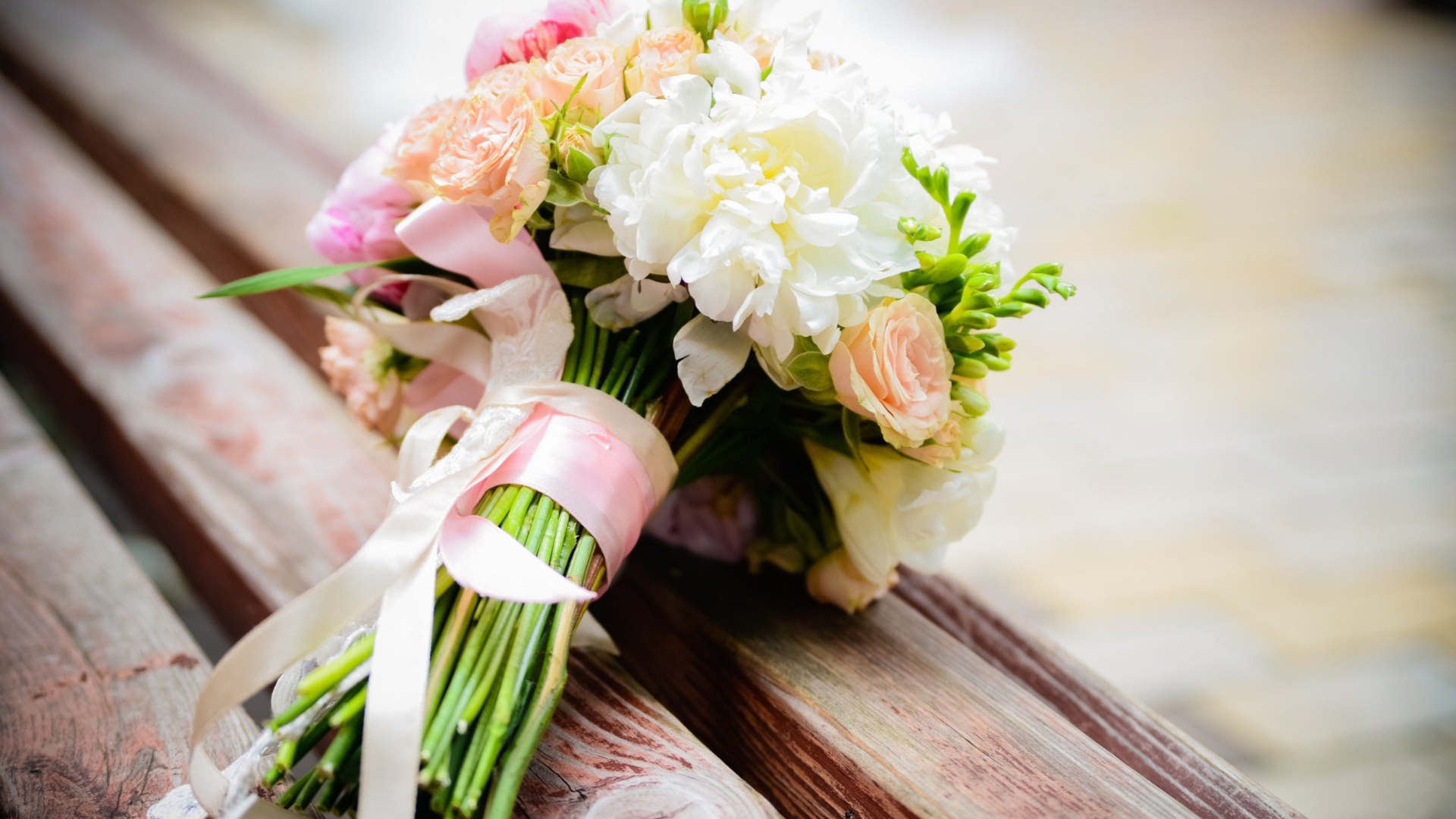 Красивый свадебный букет лежит на деревянной лавке
