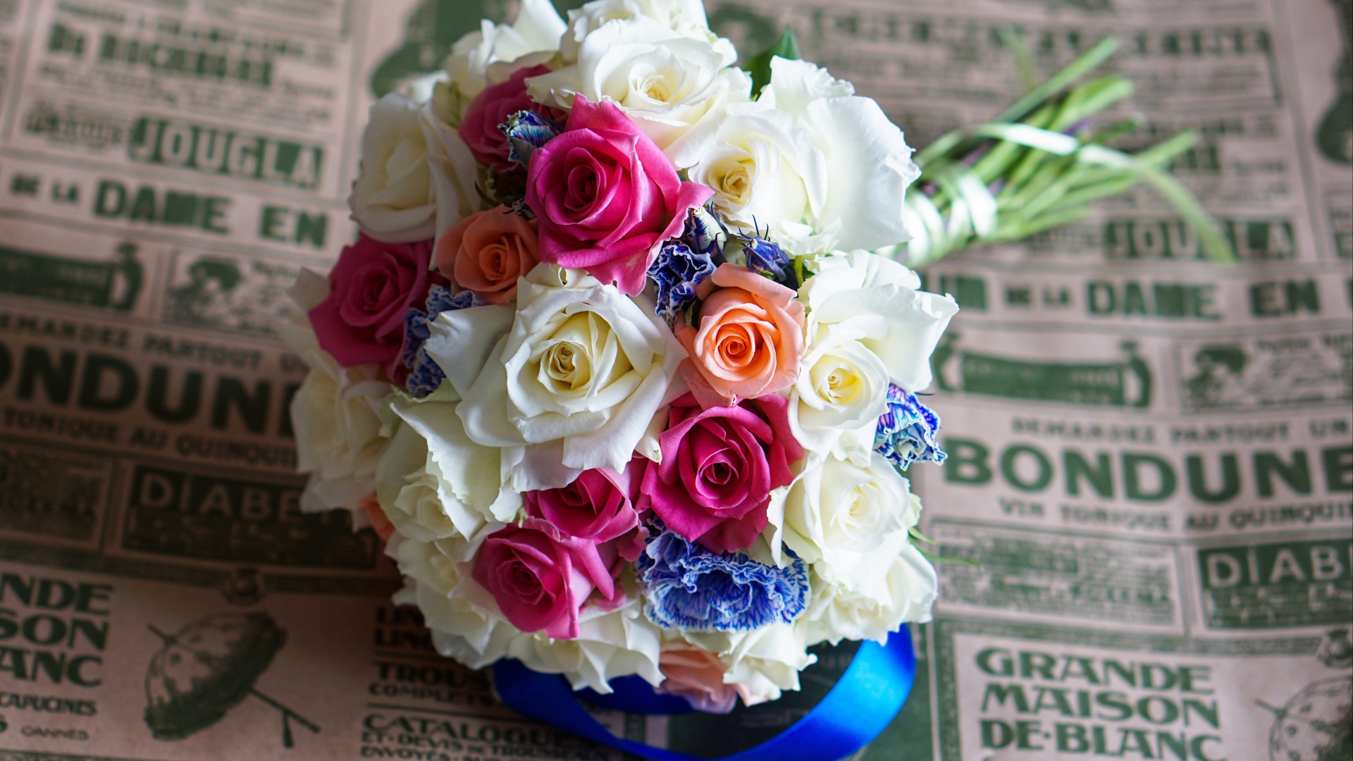 Красивый свадебный букет из роз лежит на газете