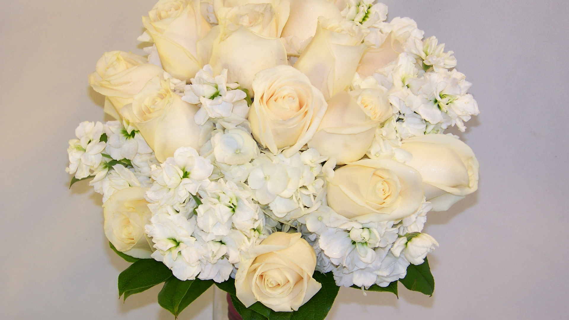 Красивый нежный букет с белыми розами и цветами гортензии на сером фоне