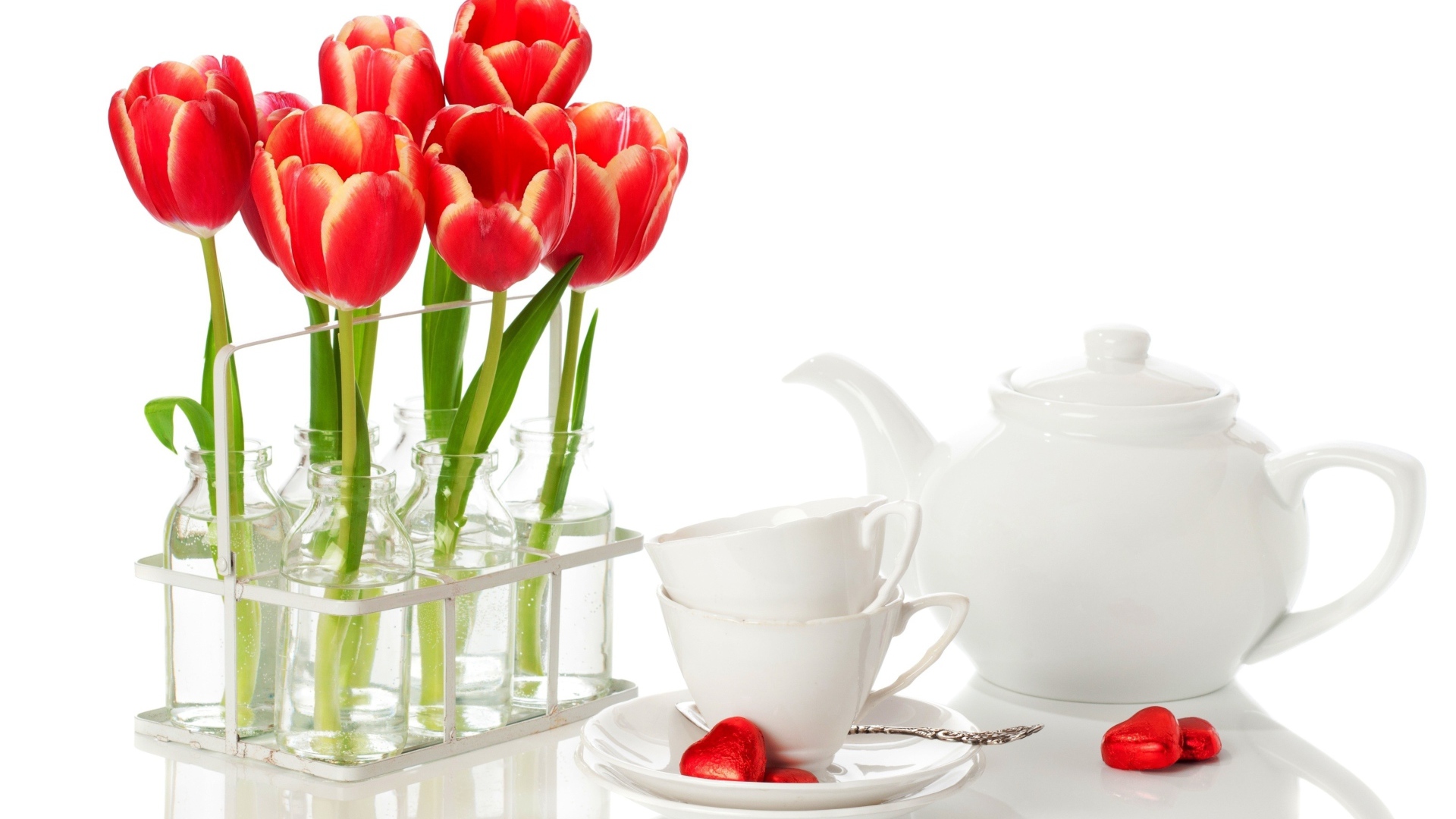 Красные тюльпаны с чайным сервизом на белом фоне